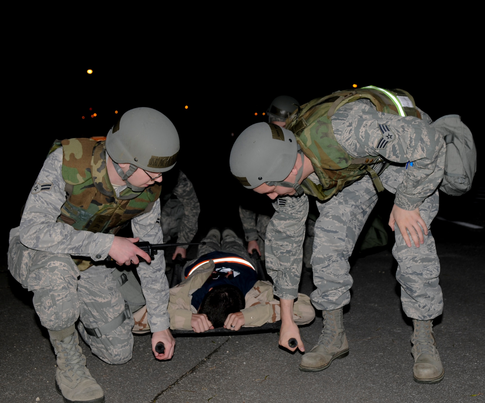 Airmen from the 18th Communication Squadron prepare to lift a litter with a simulated wounded Airmen during a training scenario for the local operational readiness exercise Beverly High 11-03, on Kadena Air Base, March 3. During the LORE Airmen are tested with different tasks to ensure they can complete the mission during real world contingencies. (U.S. Air Force photo/Airman 1st Class Brooke P. Beers)