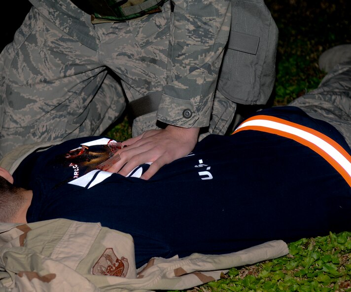 Airman 1st Class Tyler Bender, a member of the 18th Communication Squadron, applies pressure to a simulated victim during the local operational readiness exercise Beverly High 11-03, on Kadena Air Base, March 3. The scenario tested the Airmen’s ability to secure the area and provide self-aid and buddy care after a simulated attack. (U.S. Air Force photo/Airman 1st Class Brooke P. Beers)