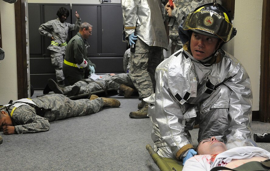 An 18th Civil Engineer Squadron firefighter secures the head of a simulated victim while others perform self-aid and buddy care to other victims during the local operational readiness exercise, Beverly High 11-03, on Kadena Air Base, Japan, March 3. The scenario tested the Airmen’s ability to respond to an active-shooter situation on base. (U.S. Air Force photo/ Staff Sgt. Darnell T. Cannady)
