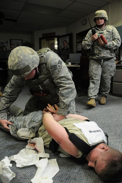 Senior Airman Daniel Miller, 18th Security Forces Squadron response force member, performs a body search on Airman 1st Class Kristopher Brummel, a simulated active shooter, while Airman Tara Wilson, 18th Security Forces Squadron response force member, radios the information to the law enforcement desk during Beverly High 11-03, a local operational readiness exercise at Kadena Air Base, Japan, March 3. The squadron used the scenario to hone Airmen’s skills during emergency situations. (U.S. Air Force photo/ Staff Sgt. Darnell T. Cannady)
