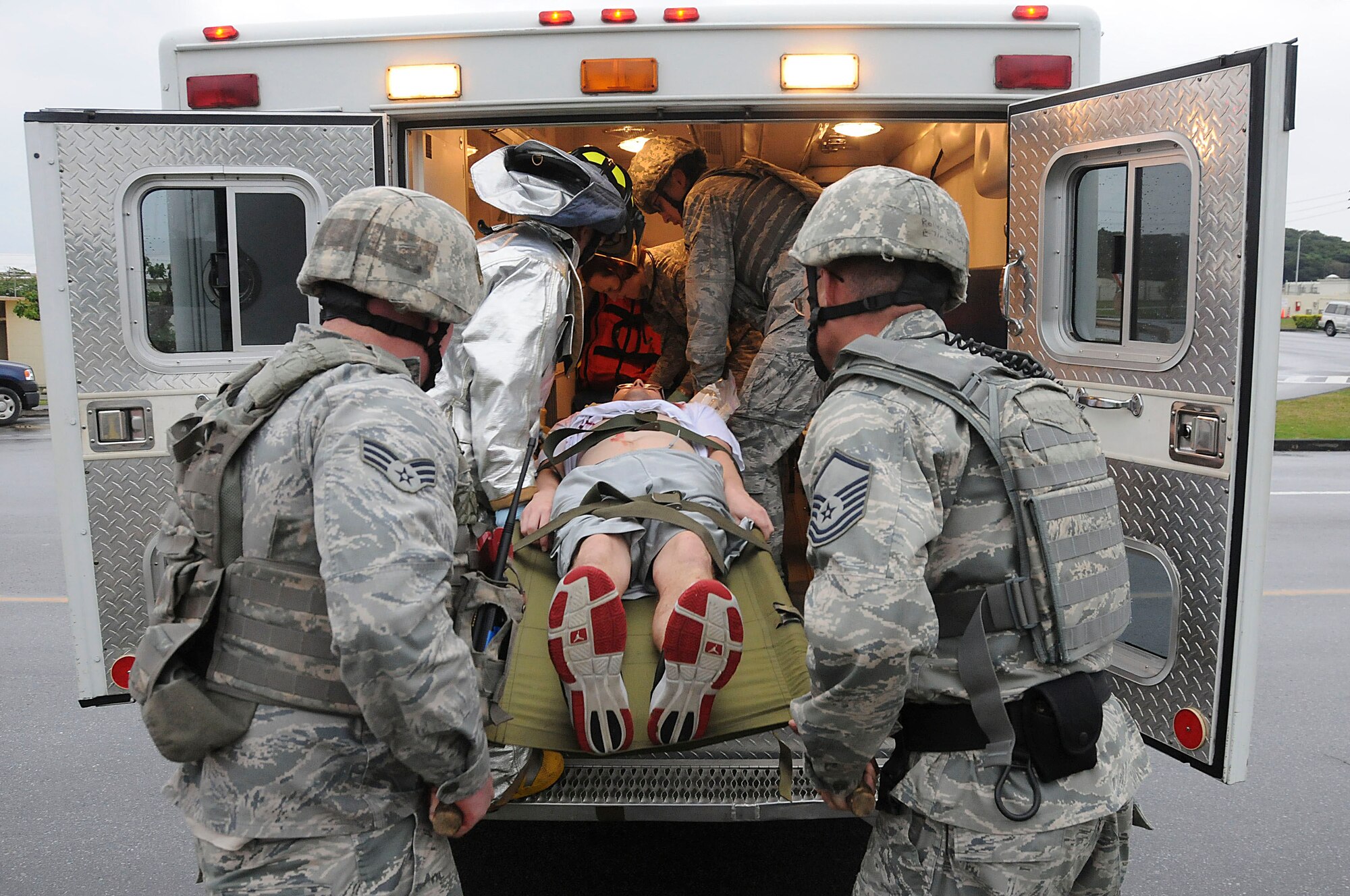 18th Wing members load a simulated victim into an ambulance during the local operational readiness exercise on Kadena Air Base, Japan, March 3. The scenario tested the Airmen's ability to stop the shooter and provide self-aid and buddy care to wounded victims during a simulated active-shooter scenario. (U.S. Air Force photo/ Staff Sgt. Darnell T. Cannady)