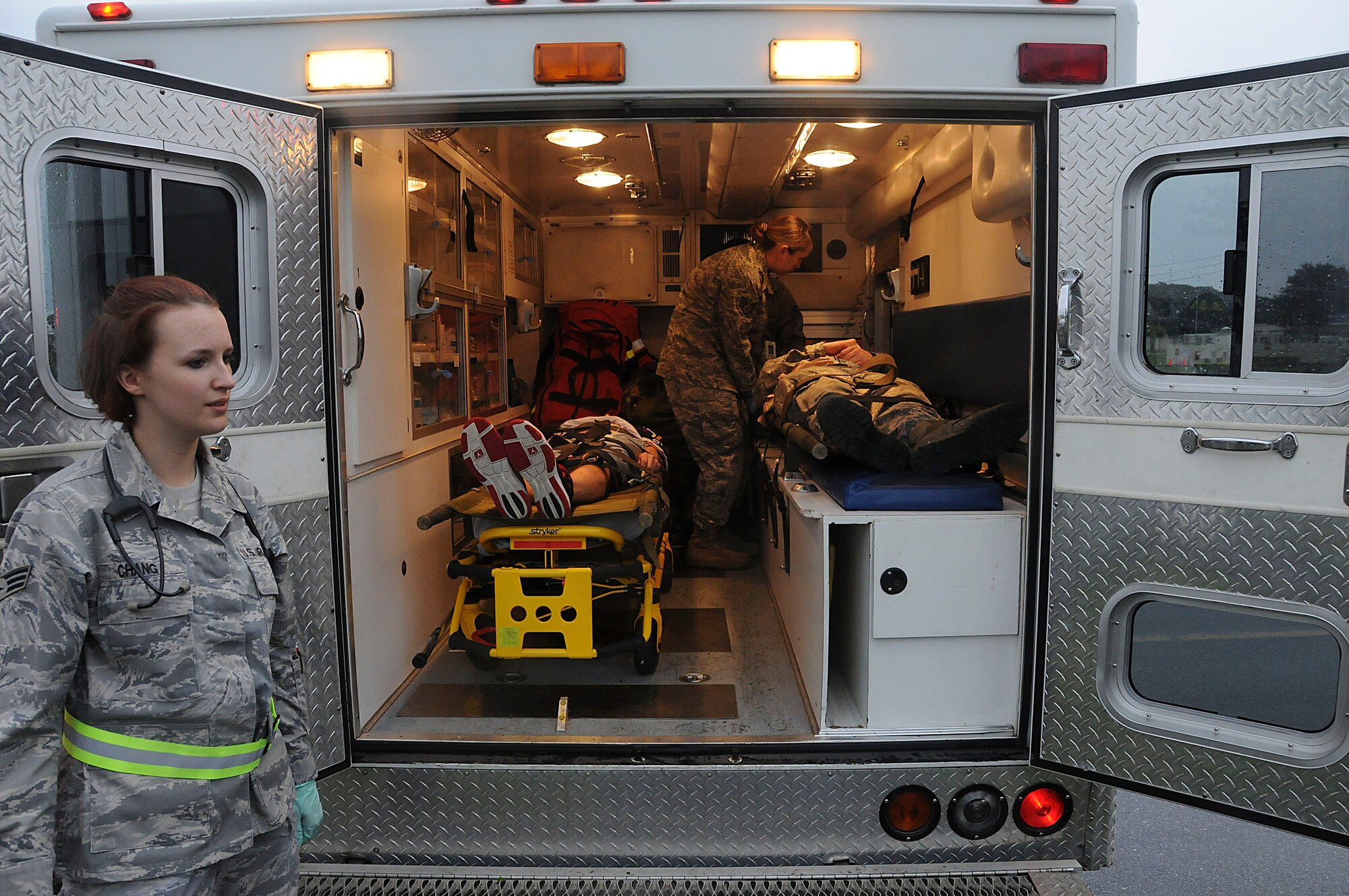 Senior Airman Krystle Chang, 18th Aerospace Medicine Squadron aerospace technician, ensures only authorized individuals enter the back of the ambulance while Staff Sgt. Sidonia Farnsworth, 18th Medical Operations Squadron medical technician, checks the status of two simulated victims during the local operational readiness exercise, Beverly High 11-03 on Kadena Air Base, Japan, March 3. This scenario tested the abilities of emergency responders to react to  an active-shooter situation on base. (U.S. Air Force photo/ Staff Sgt. Darnell T. Cannady)
