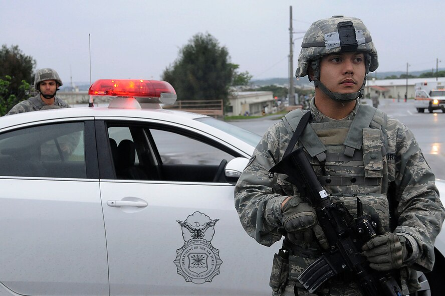Senior Airman Joseph Sayre, 18th Security Forces Squadron response force leader (right), and Senior Airman Eric Liranzo, 18th Security Forces Squadron entry controller, block the road where the simulated shooting occurred during the local operational readiness exercise on Kadena Air Base, Japan, March 3. Blocking the entrance and exit allows only essential members into the scene and allows the emergency responders to control the situation. (U.S. Air Force photo/ Staff Sgt. Darnell T. Cannady)