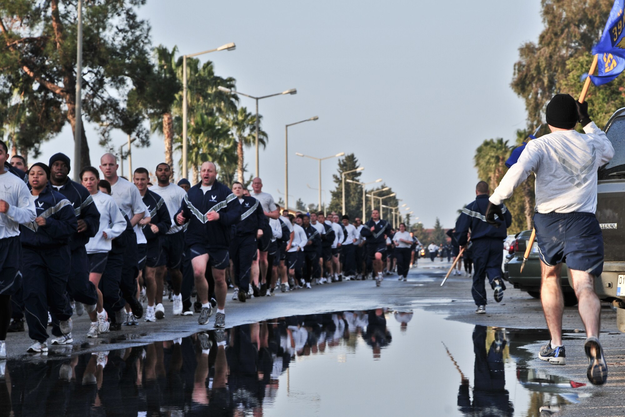 Airmen run around the formation with their unit guidons during the wing run Feb. 24, 2011, at Incirlik Air Base, Turkey. The run was intended to boost morale and build camaraderie between the Airmen and was held in conjunction with resiliency training during Winter Wingman Day 2011.  (U.S. Air Force photo by Staff Sgt. Alex Montes/Released)