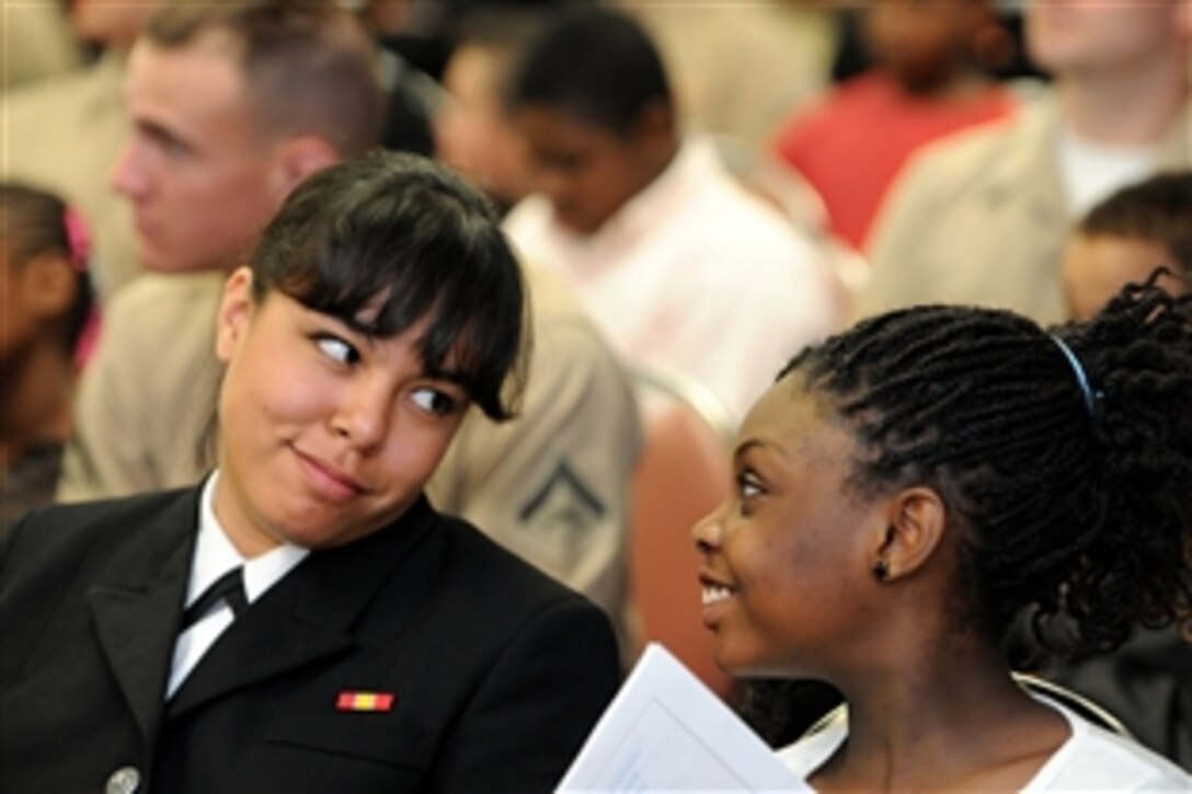 Navy Seaman Stephanie Dasilva jokes with a student at O.J. Semmes Elementary School during the graduation ceremony for the 52nd session of Saturday Scholars, in Pensacola, Fla., Feb. 26, 2011. The program is hosted by the Center for Information Dominance Corry Station. Dasilva is a Information Systems Technician and a Saturday Scholar mentor.
