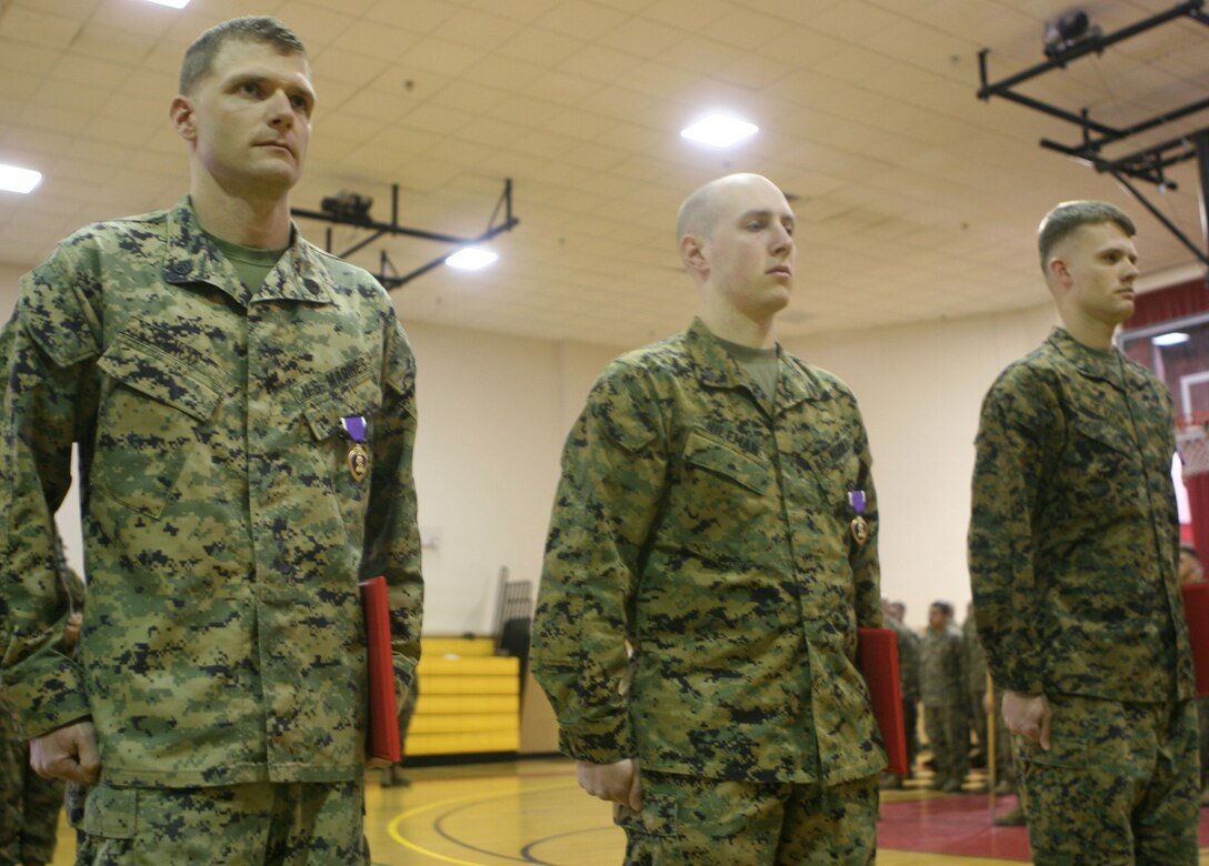 Staff Sgt. Jared V Genco (left), Sgt. Joshua M. Hileman (center) and Cpl. Trey D. Devaun stand in formation after receiving Purple Hearts aboard Marine Corps Base Camp Lejeune, N.C., March 4, 2011. The Marines, all with 2nd Assault Amphibian Battalion, 2nd Marine Division, received the awards after being wounded during a deployment to Helmand province, Afghanistan, last year.