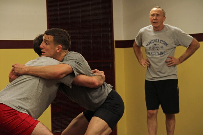 All-Marine wrestlers Sgt. Donavan Depatto, 26, from Monticello, Minn., and 1st Lt. John Cox, 26, from Grand Haven, Mich., practice body lock throws and take downs which were taught by Dan Chandler in the University of Minnesota Gopher wrestling room March 4. The All-Marine athletes received one-on-one instruction from the well-known international coach after interacting with wrestlers competing in the state high school tournament. After describing how the Marines performed well during the training session, Chandler said wrestling is all about "putting in the time and thousands of repetitions."