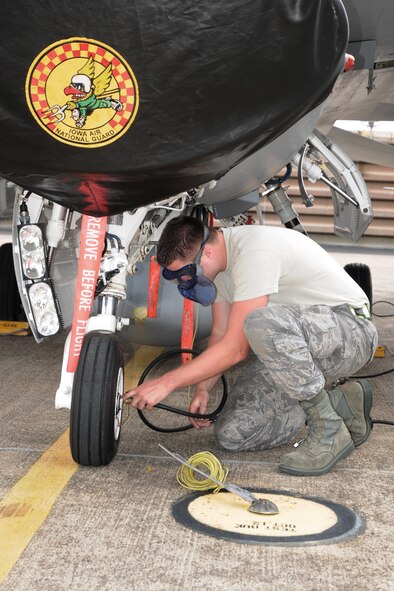 Staff Sgt. Cory Weaver, from the 132nd Fighter Wing (132FW), Des Moines, Iowa, checks the tire pressure of an F-16 aircraft and fills it with air on the flight line of the Royal Australian Air Force (RAAF) Base, Williamtown, Australia on March 4, 2011.  The 132FW is completing joint flying operation, "Sentry Down Under", with the RAAF and is in the process of re-deploying back home.  (US Air Force photo/Staff Sgt. Linda E. Kephart)(Released)   