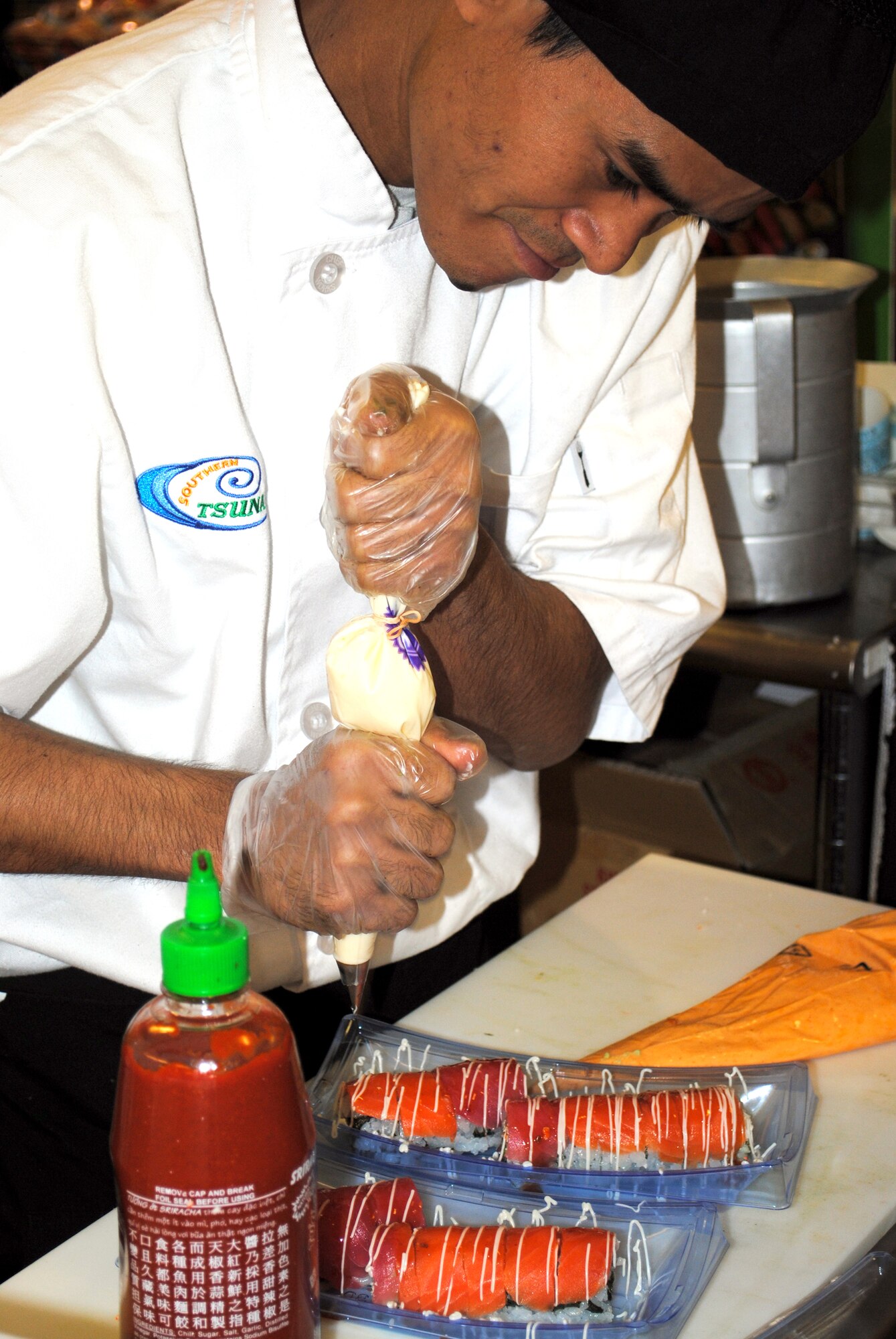Tun Aung, a sushi chef, adds the finishing touch to his sushi creation.  The handmade sushi is created every day with both taste and design in mind. (U.S. Air Force photo/Airman Cortney Hansen)