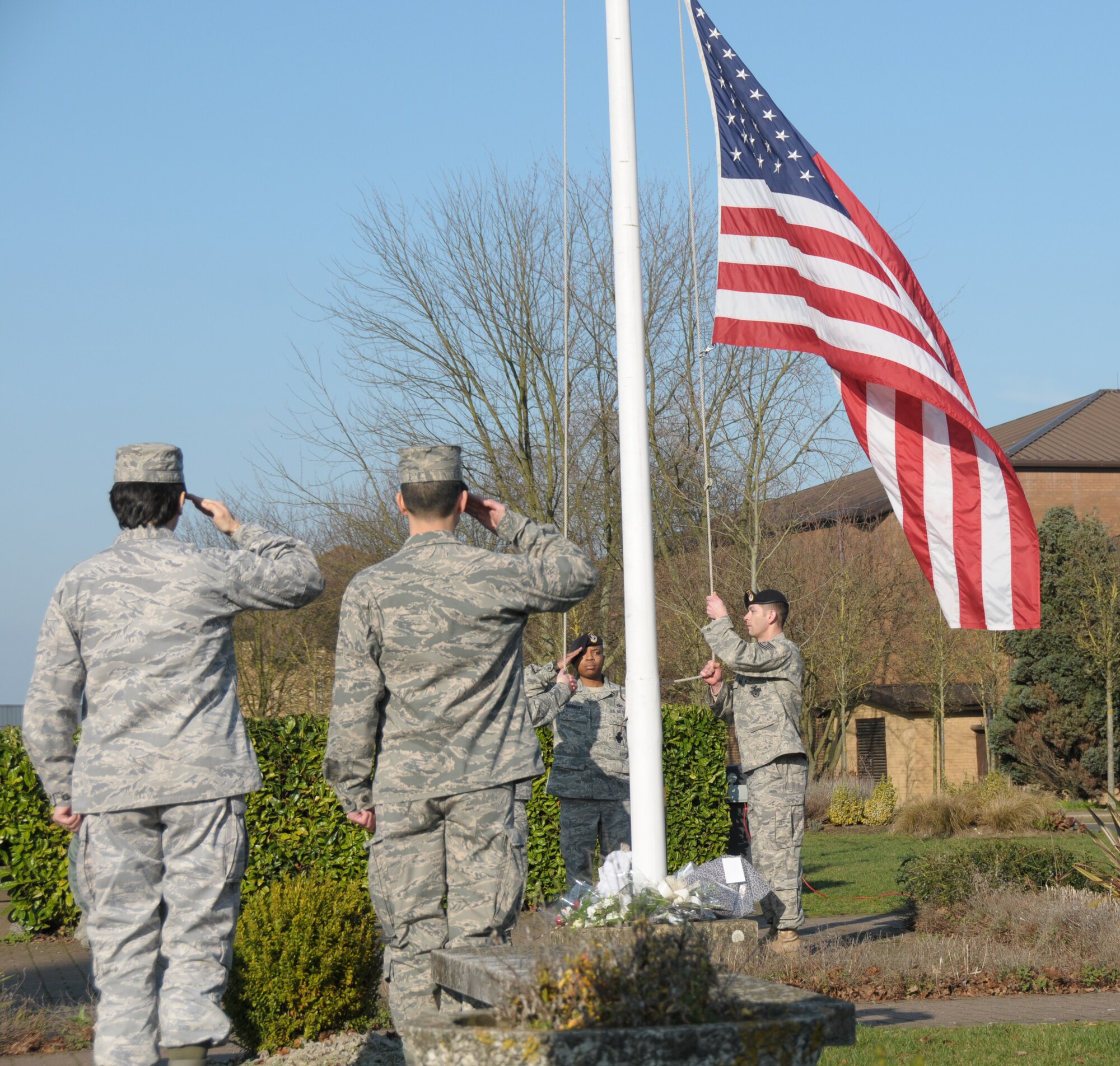 ROYAL AIR FORCE LAKENHEATH, England - A flag detail, consisting of three 48th Security Forces Squadron Airmen, lower the flag during a ceremony, held in honor of Senior Airman Nicholas Alden, on March 4. Airman Alden was killed and the two other 48th SFS Airmen were injured in a shooting at the Frankfurt International Airport March 2. (U.S. Air Force photo/Airman Cory Payne)