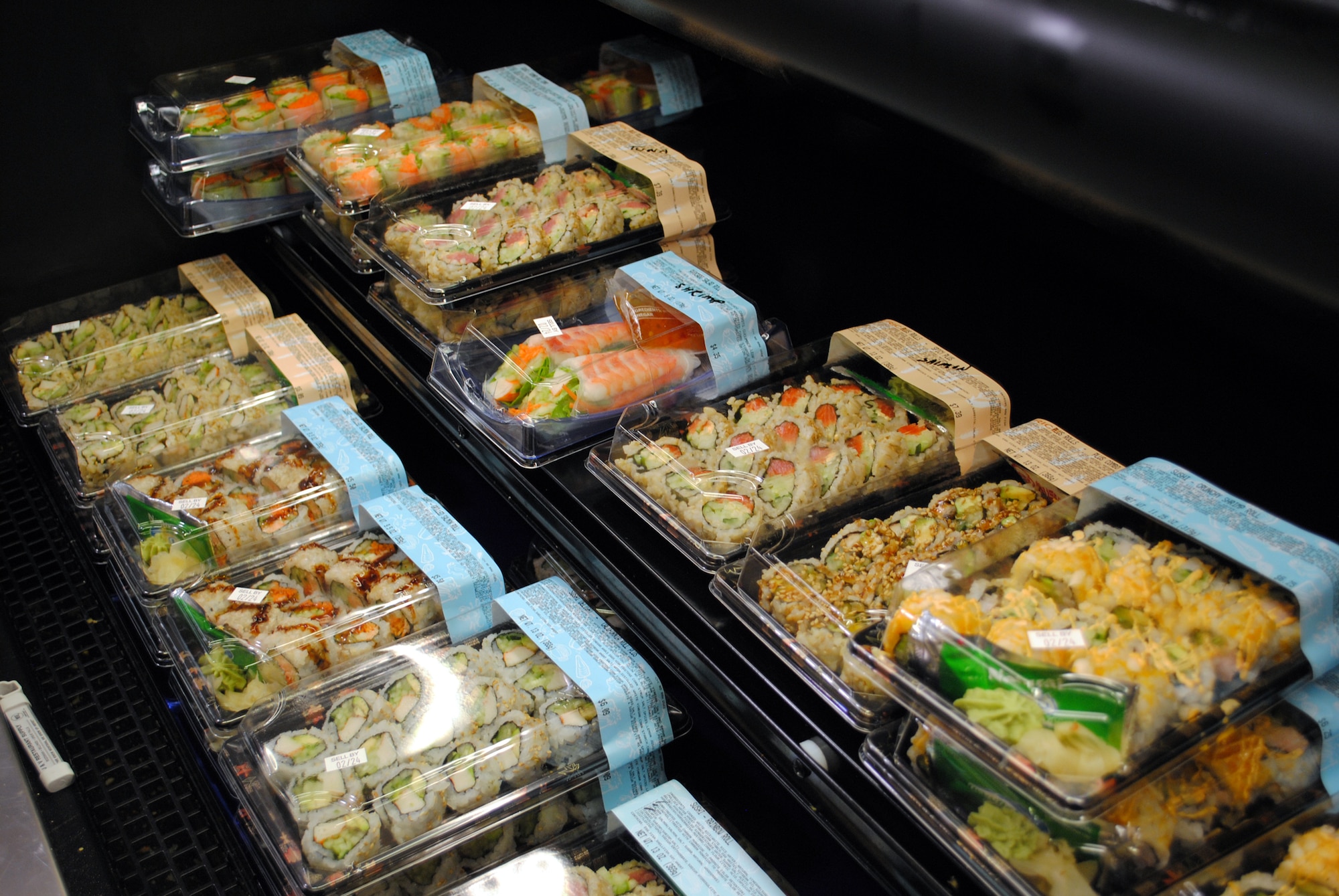 The handmade sushi is displayed in front of the sushi stand in the commissary.  The commissary's two sushi chefs produce between 120 and 140 packages of sushi every day. (U.S. Air Force photo/Airman Cortney Hansen)