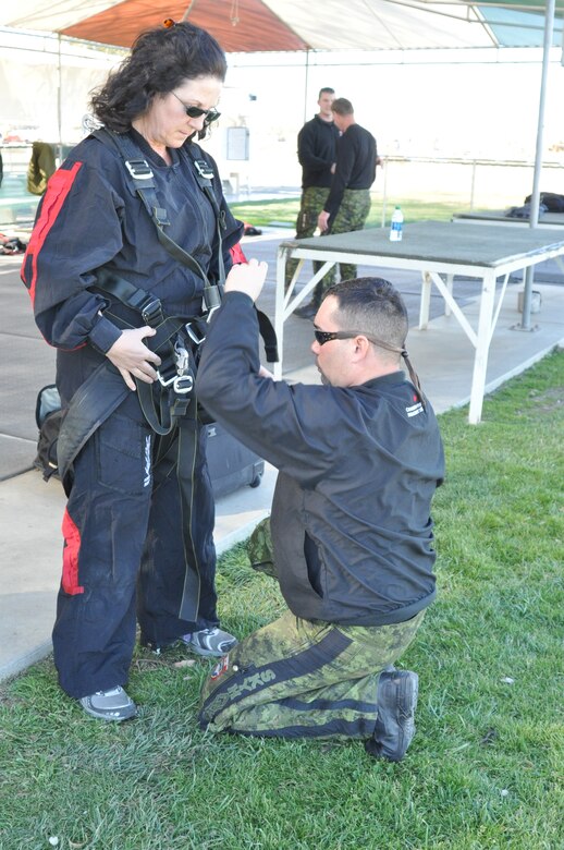 SkyHawks jumpmaster, "Scooter," adjusts the straps on Linda Welz's harness before skydiving Feb. 11.  (U.S. Air Force photo/ Megan Crusher)