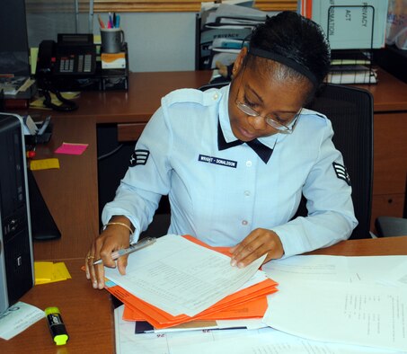 Senior Airman Kay Ann Wright-Donaldson, a 341st Force Support Squadron separation and retirement personnelist, finishes up some paperwork for a client.  Along with her primary duties, she completes additional duties at work and volunteers for a number of organizations off duty.  (U.S. Air Force photo/Airman Cortney Hansen)