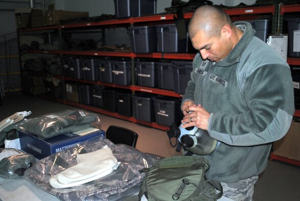 Tech. Sgt. David Garcia, 341st Civil Engineer Squadron logistics non-commissioned officer in charge, inspects a gas mask for imperfections.  He is in charge of ensuring Airmen in his squadron have the correct equipment for deployment.  (U.S. Air Force photo/Airman Cortney Hansen)