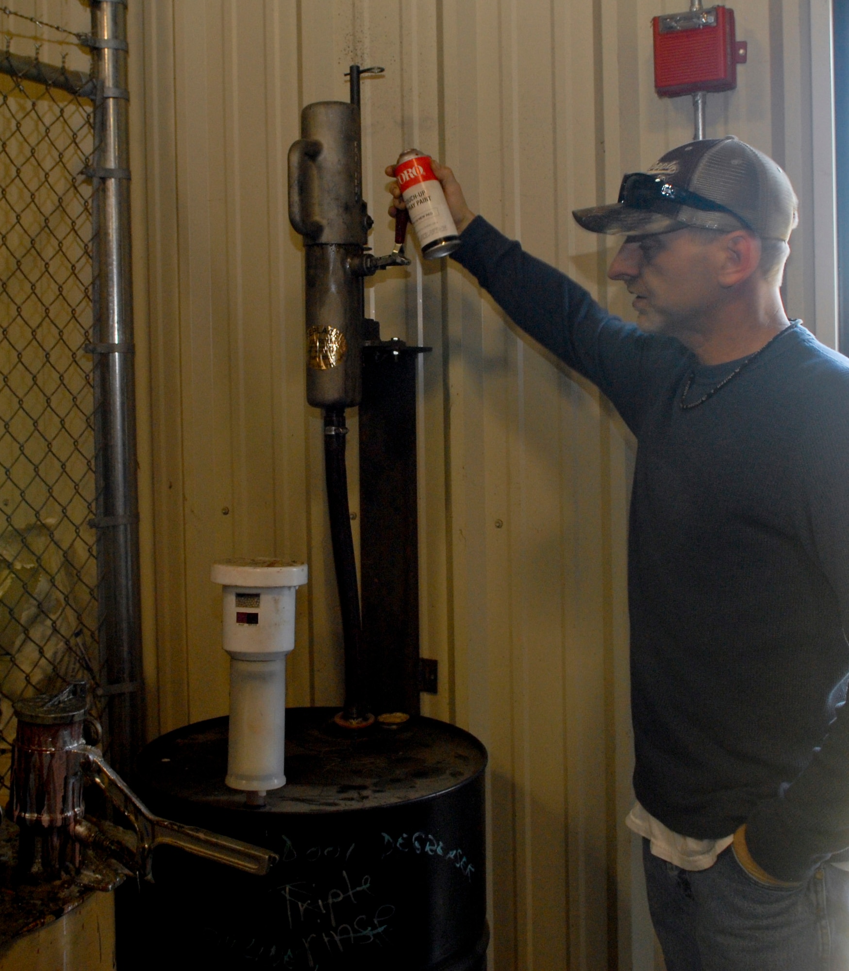 Eric Davis, 436th Civil Engineer Squadron contractor, demonstrates the aerosol can puncture machine, March 2, 2011, which is used to recycle chemicals from aerosol cans at the Dover Air Force Base, Del., Recycling Center. The Recycling Center recycles several hazardous materials so that they can be safely reused later.  (U.S. Air Force photo/Airman 1st Class Matthew Hubby)