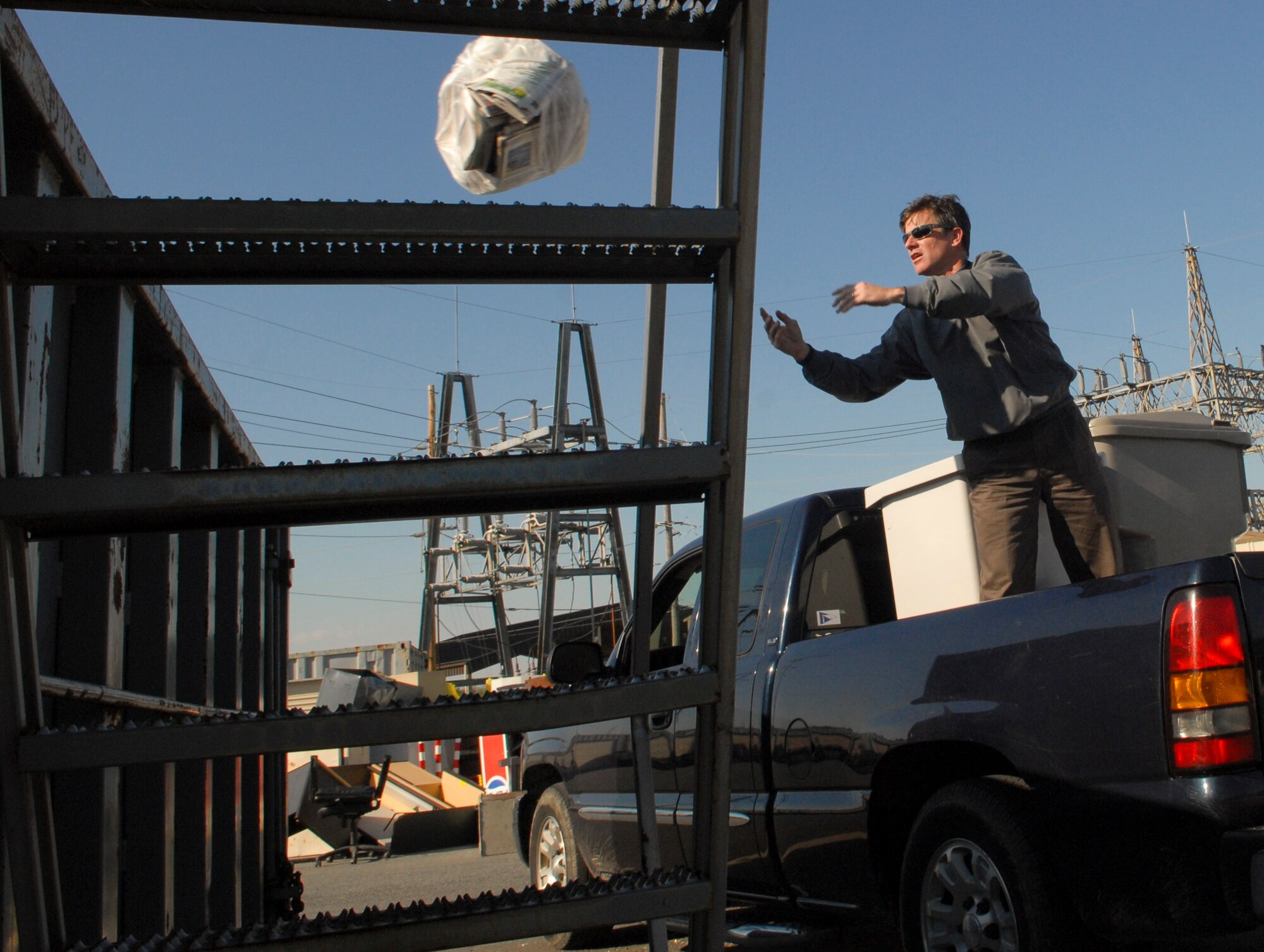 Clint Phillips, 436th Civil Engineer Squadron contractor, throws a bag of paper recycling into a roll-off bin March 2, 2011, at the Dover Air Force Base, Del., Recycling Center. The Dover AFB Qualified Recycling Program supplies bins for Team Dover to dispose of their recyclables for pick-up on base. (U.S. Air Force photo/Airman 1st Class Matthew Hubby)
