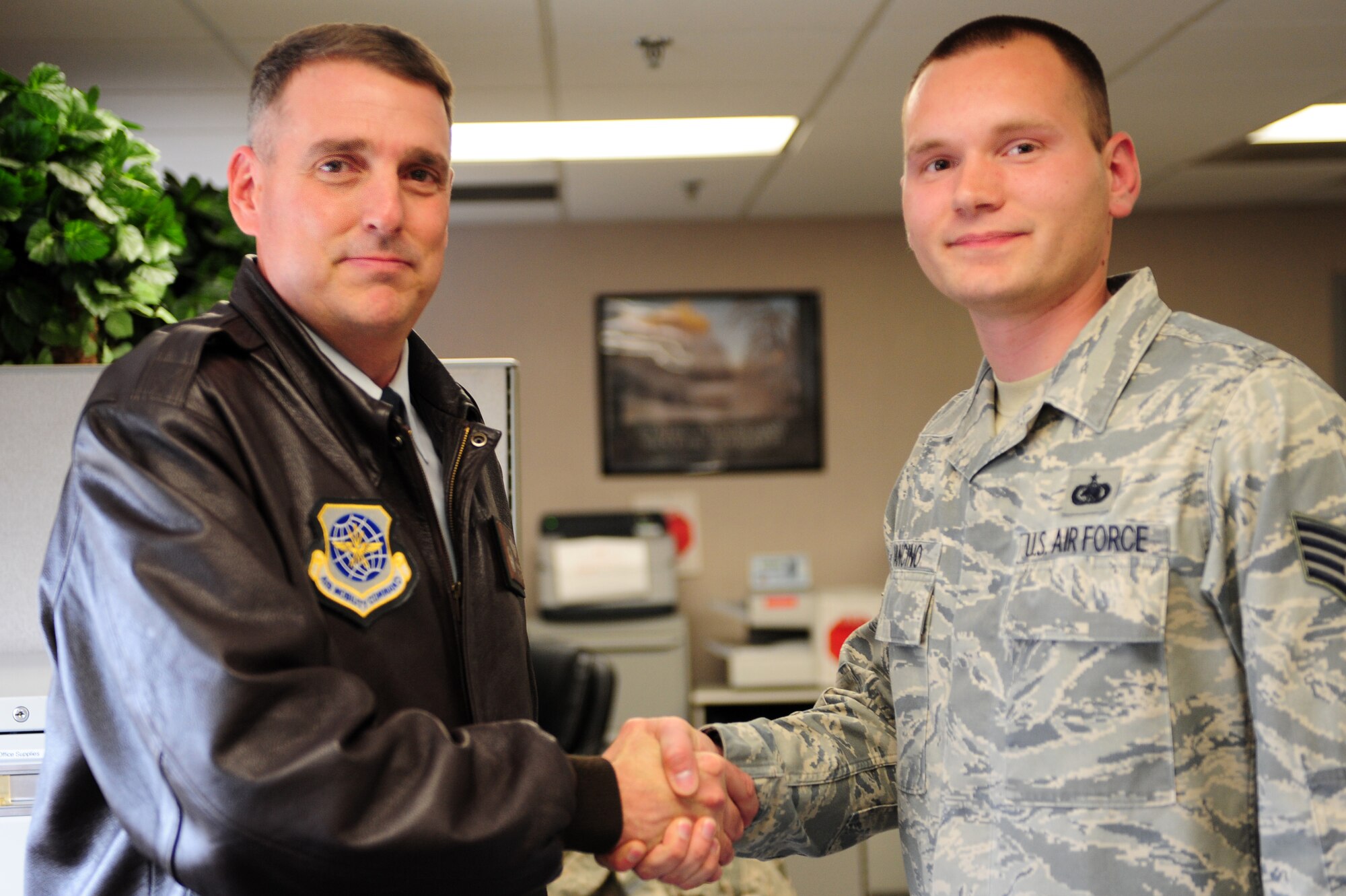 Col. Mike Minihan, 19th Airlift Wing commander, awards a coin to Staff Sgt. Frank Mancino, a 19th Logistics Readiness Squadron quality assurance NCO, as the Combat Airlifter of the Week Feb. 28, 2011, at Little Rock Air Force Base, Ark. Sergeant Mancino took the lead in setting up the air show combat fair static displays for 225,000 guests and was key to its success. (Photo by U.S. Air Force Senior Airman Jim Araos)