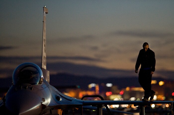 NELLIS AIR FORCE BASE, Nev. --  Airman 1st Class Jeremy Hunt, 20th Fighter Wing crew chief, Shaw Air Force Base, S.C., inspects the top of a F-16 Fighting Falcon during Red Flag 11-3, March 2. Red Flag is a realistic combat training exercise involving the air forces of the United States and its allies. The exercise is hosted north of Las Vegas on the Nevada Test and Training Range.(U.S. Air Force photo by Senior Airman Brett Clashman)