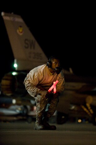 NELLIS AIR FORCE BASE, Nev. --  Senior Airman Kahlil Permenter, 20th Aircraft Maintenance Squadron crew chief, prepares to marshal a F-16 Fighting Falcon during Red Flag 11-3, March 2.  Red Flag is a realistic combat training exercise involving the air forces of the United States and its allies. The exercise is hosted north of Las Vegas on the Nevada Test and Training Range.(U.S. Air Force photo by Airman 1st Class Matthew Lancaster)


