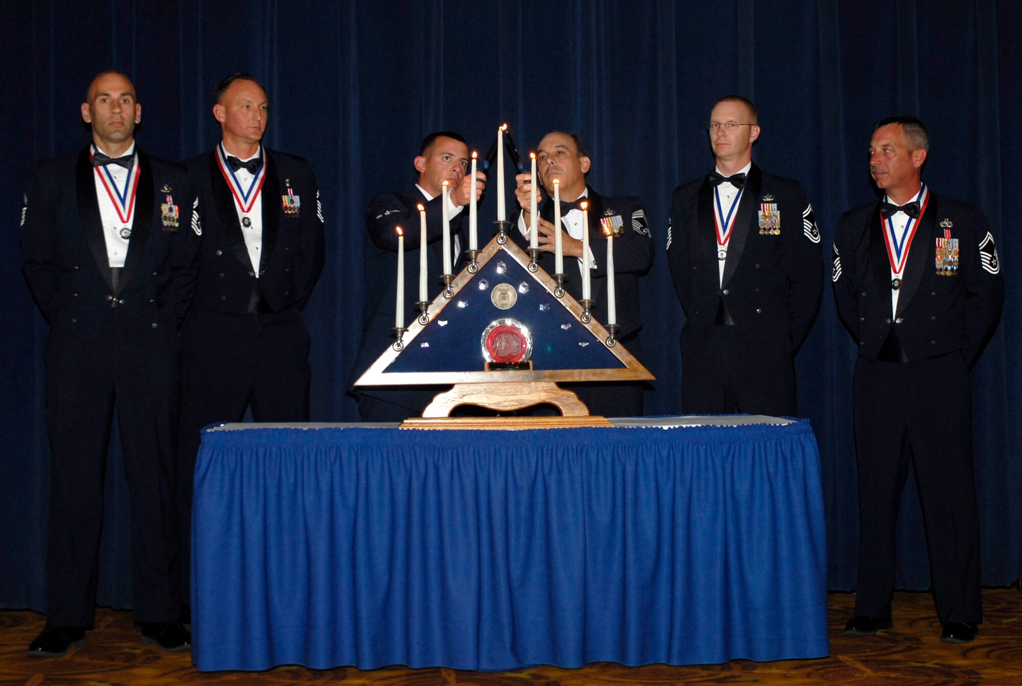 Airman Christopher Kurtz, Detachment 12, 372nd Training Squadron, and Chief Master Sgt. Justin Ouchie, 56th Logistics Support Squadron, bring their flames together lighting the last candle symbolizing the final step in becoming a chief master sergeant.  (U.S. Air Force photo/Airman 1st Class Sandra Welch)