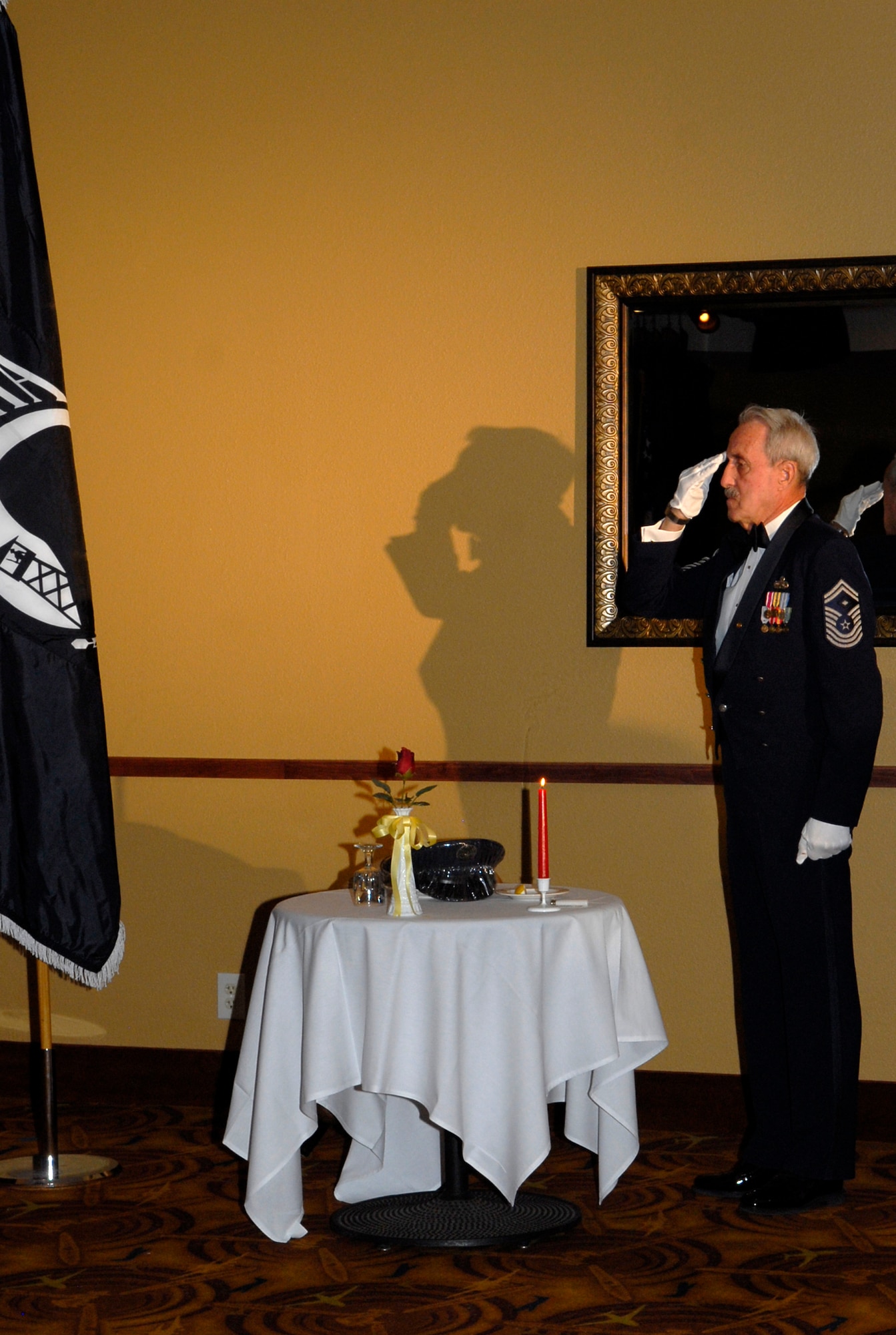 Retired Chief Master Sgt. Geon Piccoli salutes the POW/MIA table during the Luke Air Force Base Chief Recognition Ceremony on Feb. 25th.  Club Five Six hosted the ceremony to welcome four Luke Airmen into the ranks of the top 1 percent of the enlisted force.   (U.S. Air Force photo/Airman 1st Class Sandra Welch)