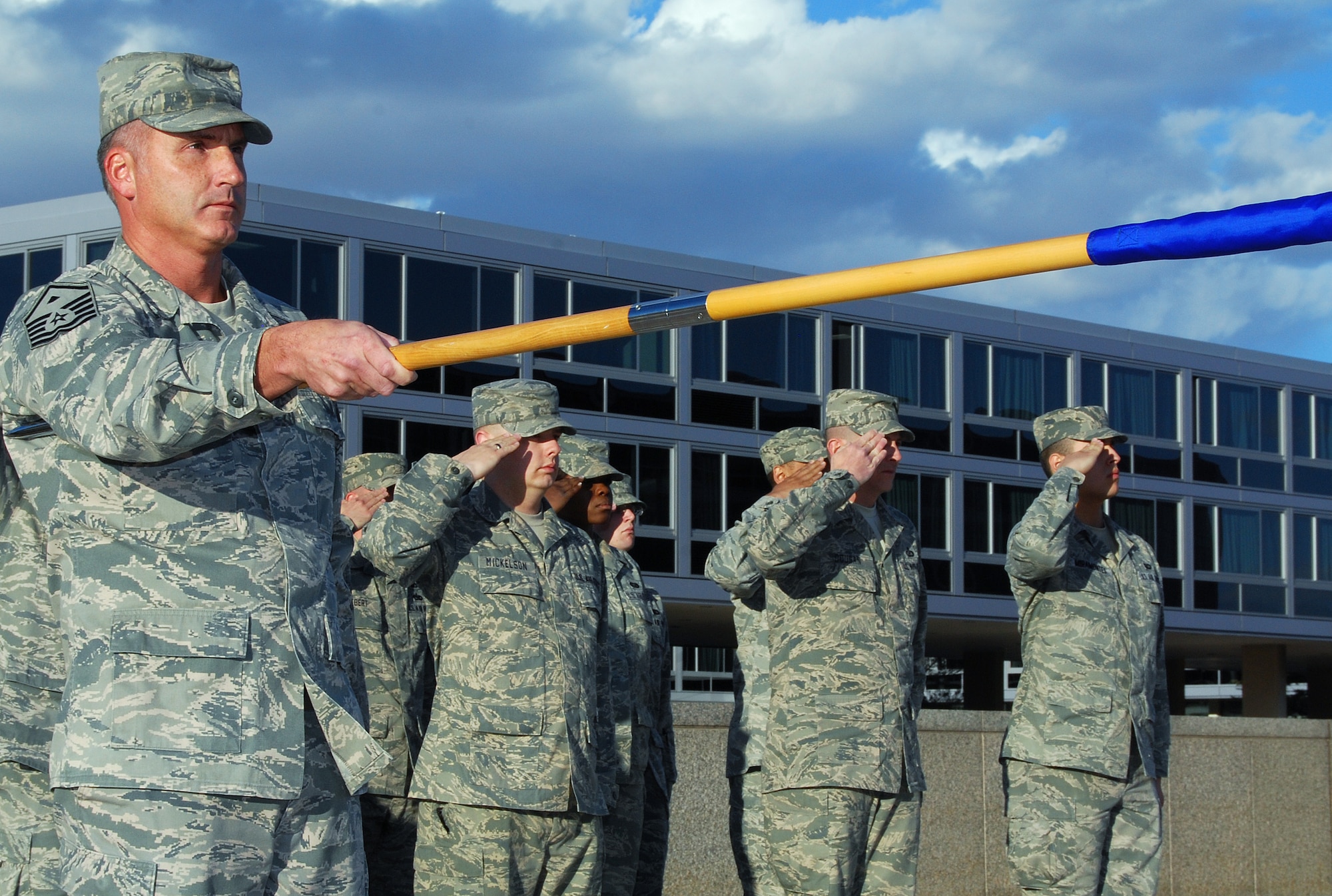Master Sgt. Greg Meinert, left, and other Airmen assigned to the Air Force Academy observe retreat during a ceremony in the Academy's Terrazzo March 3, 2011. Sergeant Meinert, the Headquarters Section first sergeant, served as guidon bearer for the ceremony. (U.S. Air Force photo/Staff Sgt. Don Branum)