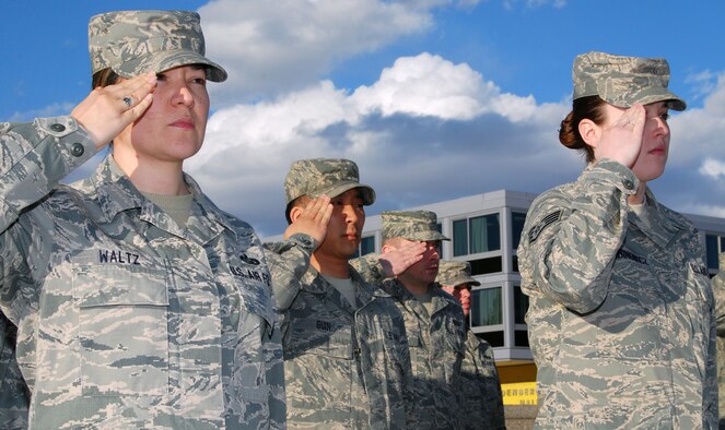 Tech. Sgt. Julie Waltz, left, and other Airmen stationed at the Air Force Academy observe retreat during a ceremony in the Terrazzo March 3, 2011. Sergeant Waltz is the NCO in charge of cadet classifications and assignments for the Academy's Directorate of Manpower and Personnel. (U.S. Air Force photo/Staff Sgt. Don Branum)