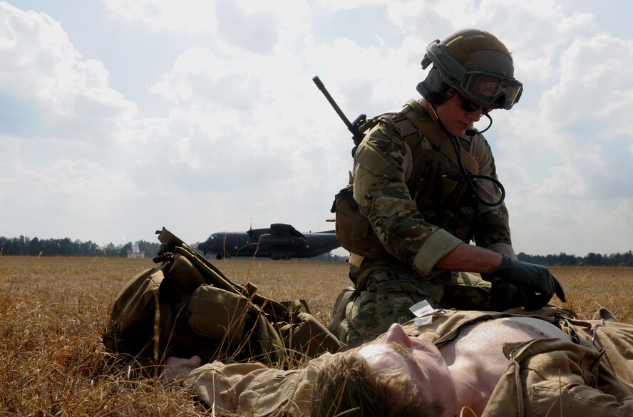 VALDOSTA, Ga.-- Senior Airman Alexander Williams, 38th Rescue Squadron pararescueman, treats an injured Airman during training as an HC-130P Combat King lands nearby during recent training. During the scenario, the pararescuemen had to examine each injured victim and treat the injuries by severity. (U.S. Air Force photo/Airman 1st Class Benjamin Wiseman)(RELEASED)
