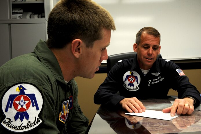 Lt. Col. Jason Koltes, Thunderbird 7, U.S. Air Force Air Demonstration Squadron "Thunderbirds" Operations Officer, and NASCAR driver Carl Edwards, review flight plans at the Thunderbird hangar, Nellis Air Force Base, Nev., Mar. 3. Edwards, who drives the #99 car, will compete in NASCAR races March 5-6 at the Las Vegas Motor Speedway.(U.S. Air Force Photo/Staff Sgt. Larry E. Reid Jr., Released)