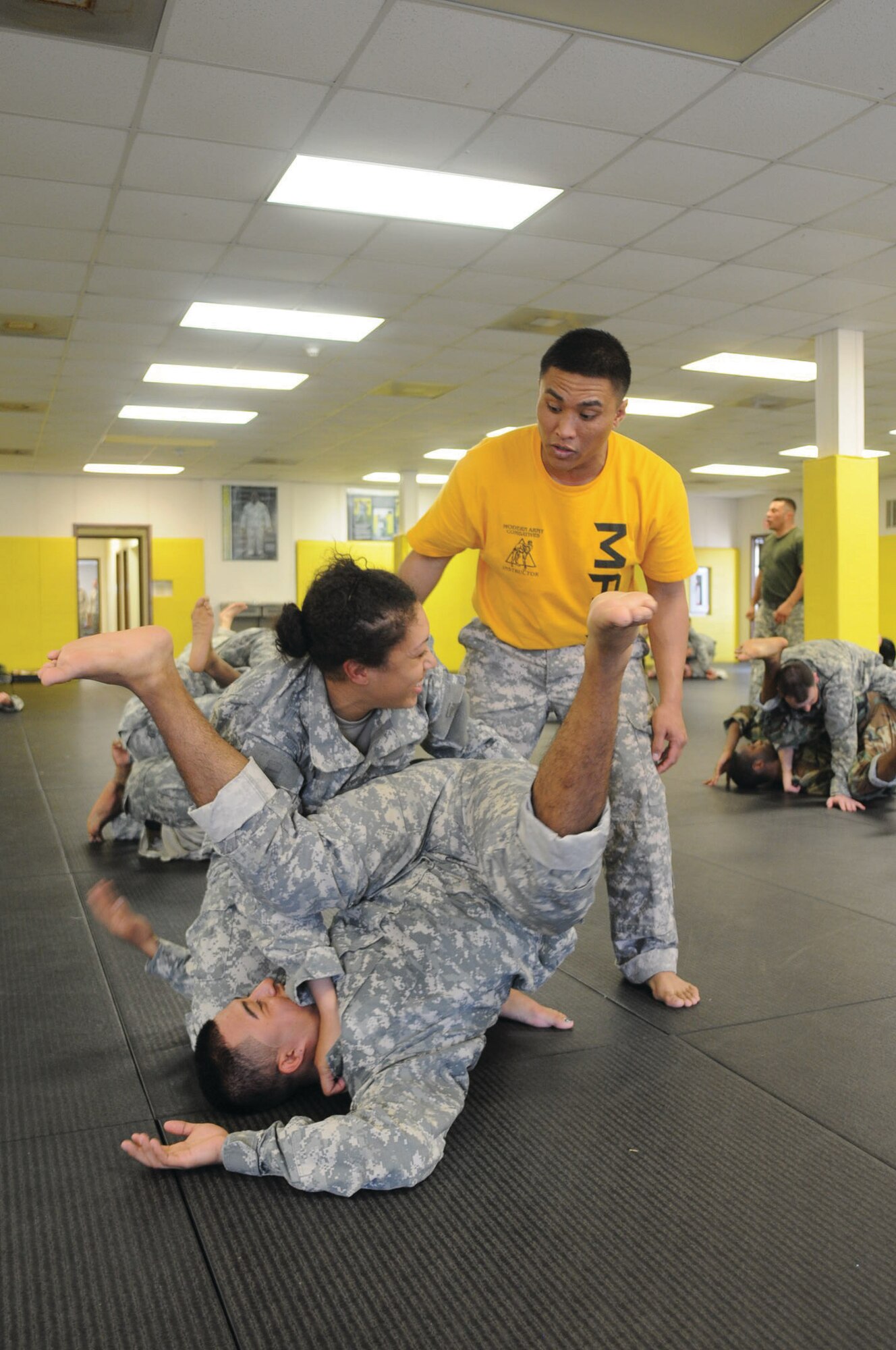 Sgt. Allen Alcarez, MACP training instructor, walks Pfc. Maria Cubera, 689th RPOE, and Pfc. Jose Toledo, 688th RPOE, through a Pass-the-Guard technique. (Photo by Tetaun Moffett)