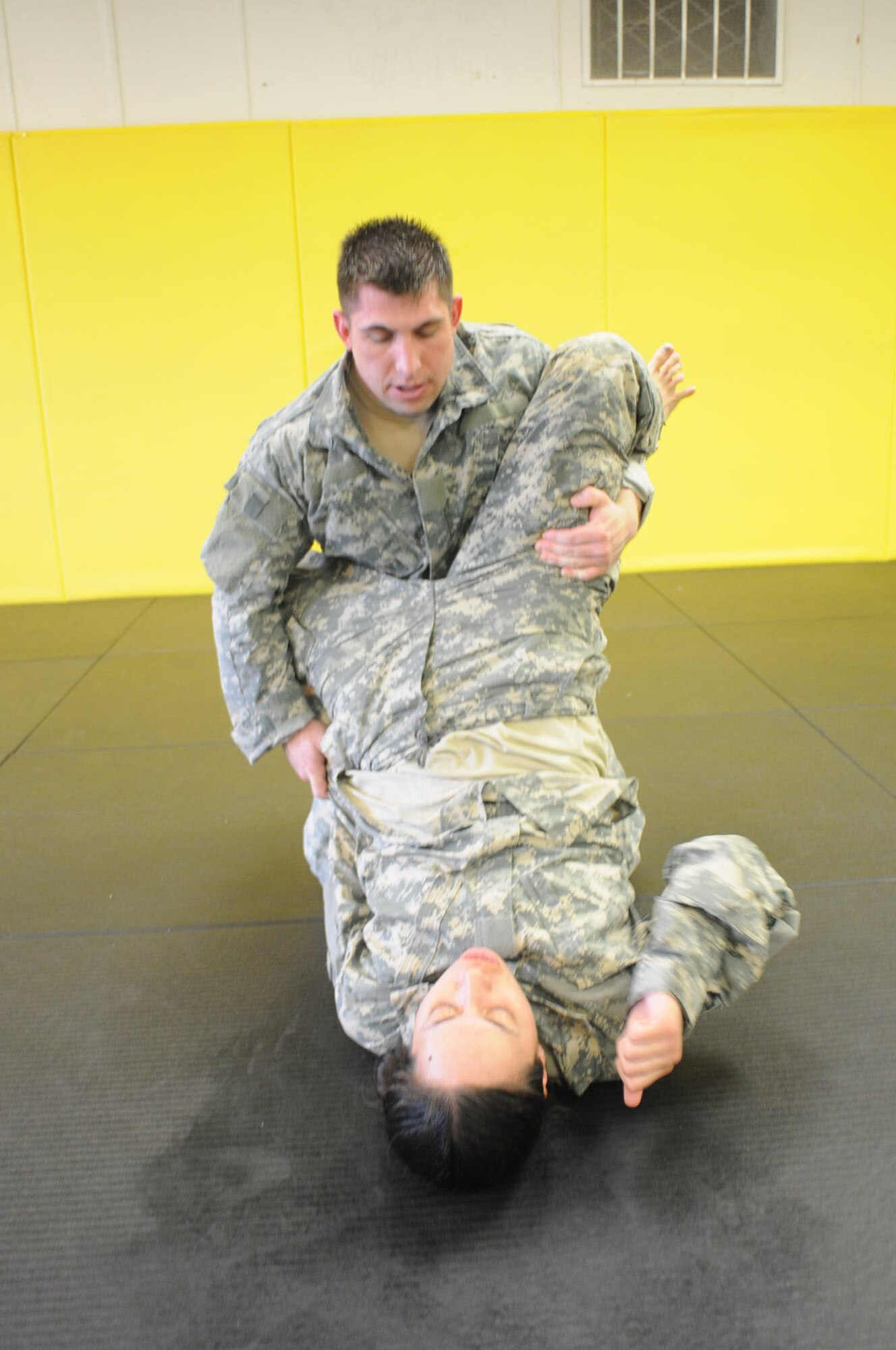 Pvt. Amanda Alaelua, 690th Rapid Port Opening Element, 597th Transportation Brigade, Surface Deployment and Distribution Command, grapples with Staff Sgt. Byron Pangbuln, 1st Staff and Faculty, USAALS, during phase one of three basic fighting strategies of the Modern Army Combatives Program.

