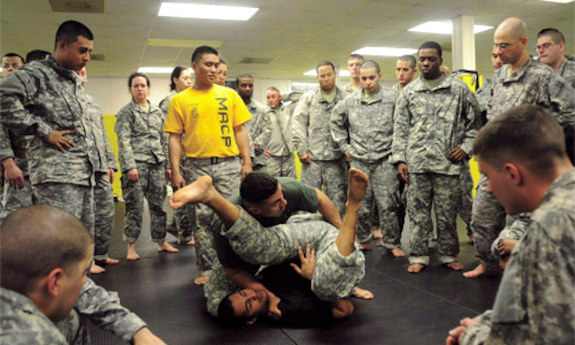 Sgt. 1st Class Luis Romero, United States Army Aviation Logistics School and combative instructor, demonstrates how to finish the fight with MACP instructor Spc. William Landastoy, Combat Support Hospital, during phase one of three basic fighting strategies of the Modern Army Combatives Program. (Photo by Tetaun Moffett)


