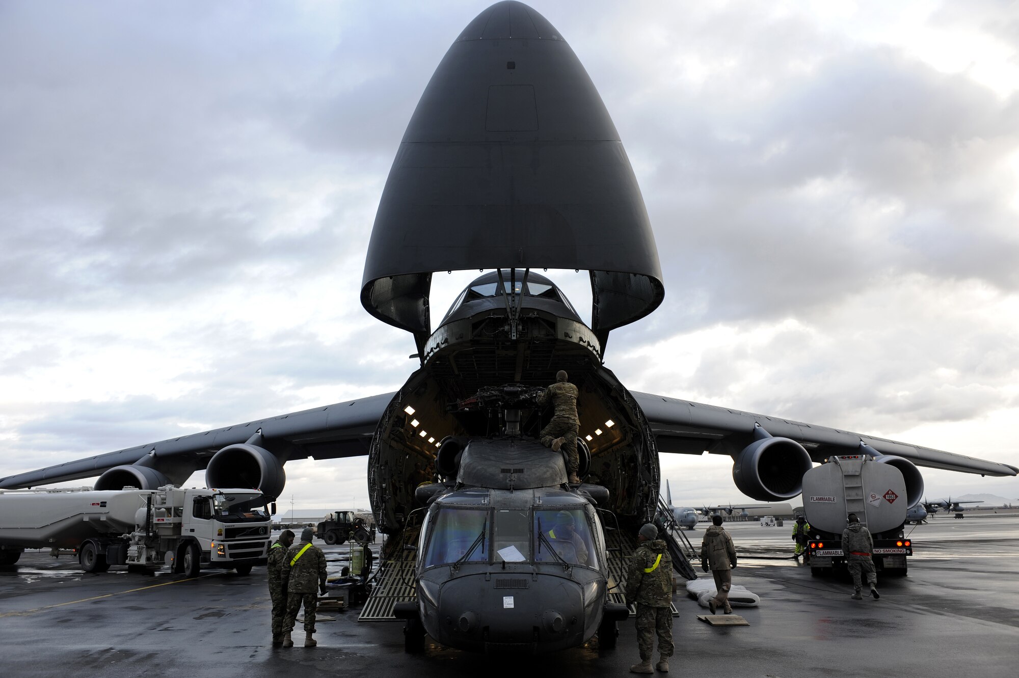 Soldiers spot a UH-60L Blackhawk while it is being loaded onto a C-5 Galaxy, Mar. 2, 2011, at Kandahar Airfield, Afghanistan. The Blackhawk upload was part of a change out; the old helicopters are being replaced by new airframes. The Soldiers are assigned to the 563rd Aviation Support Battalion out of Fort Campbell, Ky. (U.S. Air Force photo/Senior Airman Willard E. Grande II/Released)