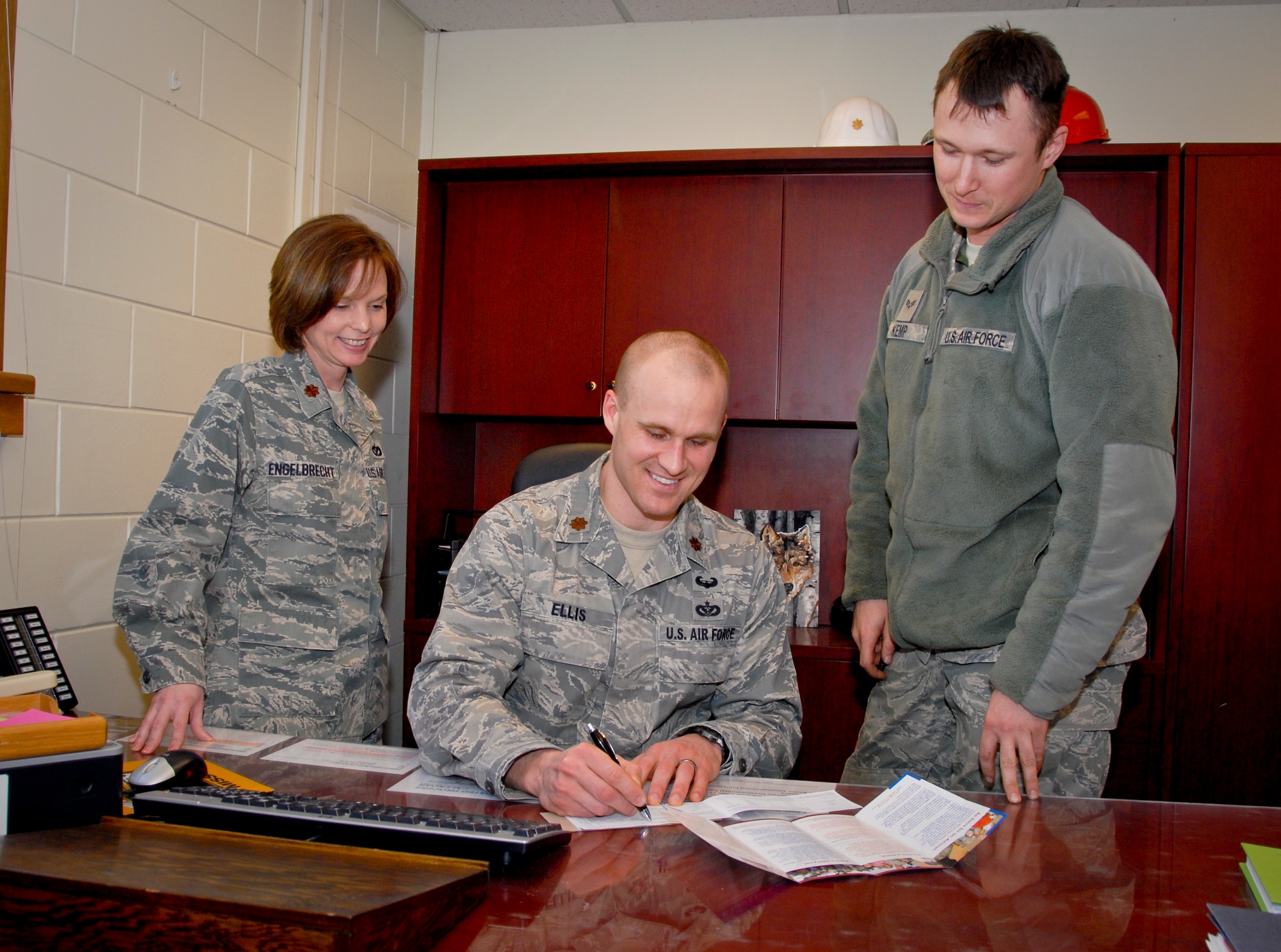 KUNSAN AIR BASE, Republic of Korea -- Maj. Roxane Engelbrecht, 8th Civil Engineer Squadron deputy commander, and Senior Airman Quinton Kemp, 8th CES Air Force Assistance Fund unit representative, watch as Maj. Brian Ellis, 8th CES chief of operations, completes his AFAF donation slip here March 3. The Kunsan AFAF campaign ends March 18. (U.S. Air Force photo/Staff Sgt. Amanda Savannah)