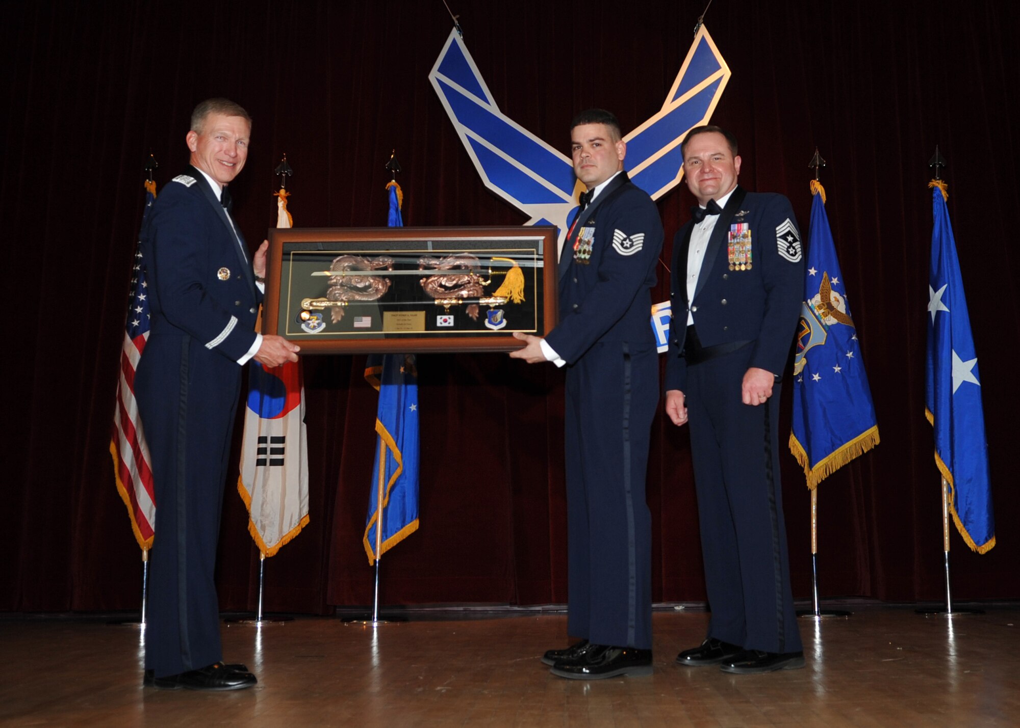OSAN AIR BASE, Republic of Korea -- Lt. Gen. Jeffrey Remington, 7th Air Force commander, and Chief Master Sgt. Tom Baker, 7th AF command chief, present Tech. Sgt. Yusef Saad, 8th Logistics Readiness Squadron compliance and environmental NCO in charge, with the 7th AF NCO of the Year award at a banquet here Feb. 27. (U.S. Air Force photo/Senior Airman Evelyn Chavez)