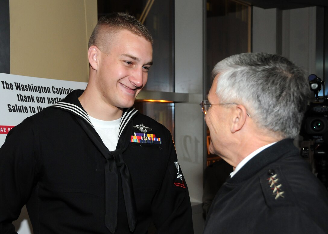 Navy Petty Officer First Class Max Rohn, a hospital corpsman who earned the Purple Heart for injuries suffered in Iraq, converses with Army Chief of Staff Gen. George W. Casey Jr. during the reception of the Washington Capitals 8th Annual Military Appreciation Night at the Verizon Center, Washington, D.C., March 3, 2011. DOD photo by Navy Petty Officer 2nd Class William Selby