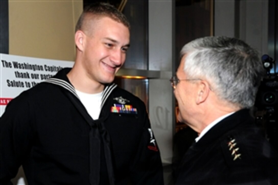 Navy Petty Officer 1st Class Max Rohn, left, who earned the Purple Heart for injuries suffered in Iraq in May 2009, talks with Army Chief of Staff Gen. George W. Casey during a reception before the the start of the Washington Capitals hockey team's 8th Annual Military Appreciation Night, at the Verizon Center in Washington, D.C., March 3, 2011. 