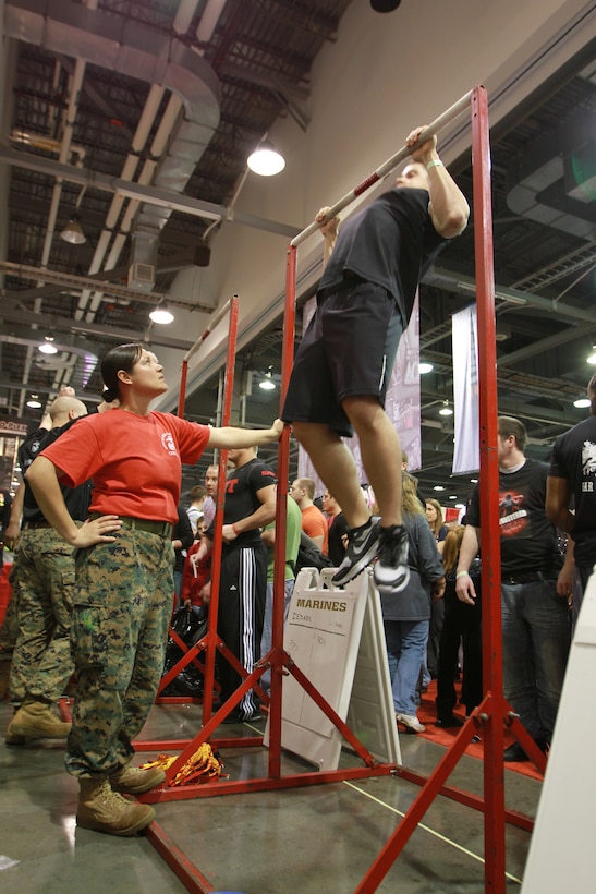 Capt. Lidia Murillo, an officer selection officer with Recruiting Station Charleston, W.Va., monitors the pull-ups of one of the participants during the Arnold Sports Festival, March 5. The annual event featured more than 700 fitness booths, including the Marine Corps pull-up challenge, for the more than 175,000 visitors to walk around and explore.  The fitness expo began in 1989 as strictly a men’s body building competition and has since expanded into more than 40 different sports throughout the Columbus area, for men and women, becoming the world’s largest multi-sport fitness weekend.  (Official U.S. Marine Corps photo by Sgt. Michael Stevens) (released)