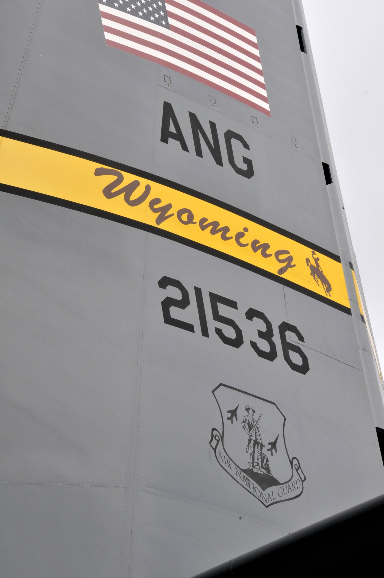 The tail of this Wyoming Air National Guard C-130 proudly displays the American Flag, the aircraft's tail number, the Air National Guard crest and the Wyoming Air National Guard "Tail Flash". Over this weekend, Feb. 25-27, 2011, contractors, along with maintenance personnel from the 153rd Aircraft Maintenance Squadron, will replace all four of the aircraft's 8-blade propellors with 4-blade systems. (USAF Photo by Master Sgt. Paul Mann)(Released)
