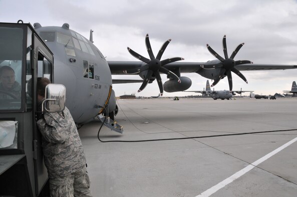 Master Sgt. Mark Gwin (left) and Staff Sgt. Adam Brannon, aerospace maintainers with the 153rd Aircraft Maintenance Squadron, Wyoming Air National Guard, prepare to tow this WyANG C-130 off of the parking ramp of their Cheyenne base on Feb. 24, 2011. The aircraft will undergo a transformation over the weekend, having all four of it's 8-blade propellors replaced with 4-blade systems. (USAF Photo by Master Sgt. Paul Mann)(Released)