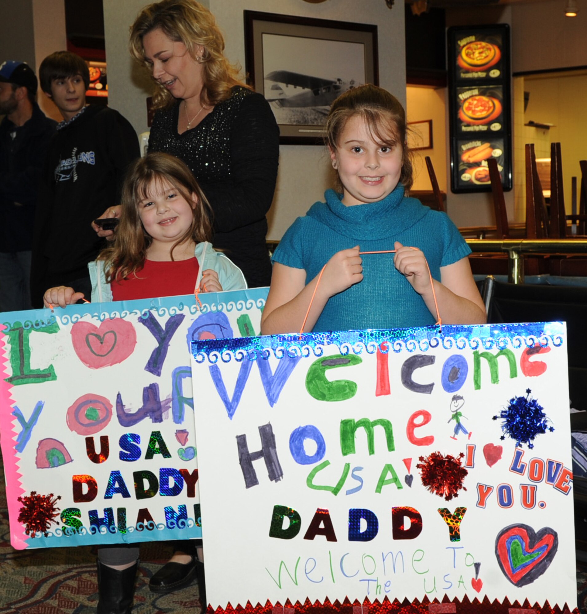 Shianne Moore, 6, (left) and Lauren Moore, 8, show signs of support for
their father, Senior Master Sgt. David Moore, a civil engineer from the
931st Air Refueling Group, while awaiting his arrival at the Mid-Continent
Airport in Wichita, March 4. Moore was one of 31 Air Force Reserve members
from the 931st Air Refueling Group who returned from a six month deployment
to Iraq and other parts of Southwest Asia in support of Operation New Dawn.
(Air Force photo by Tech. Sgt. Brannen Parrish)
