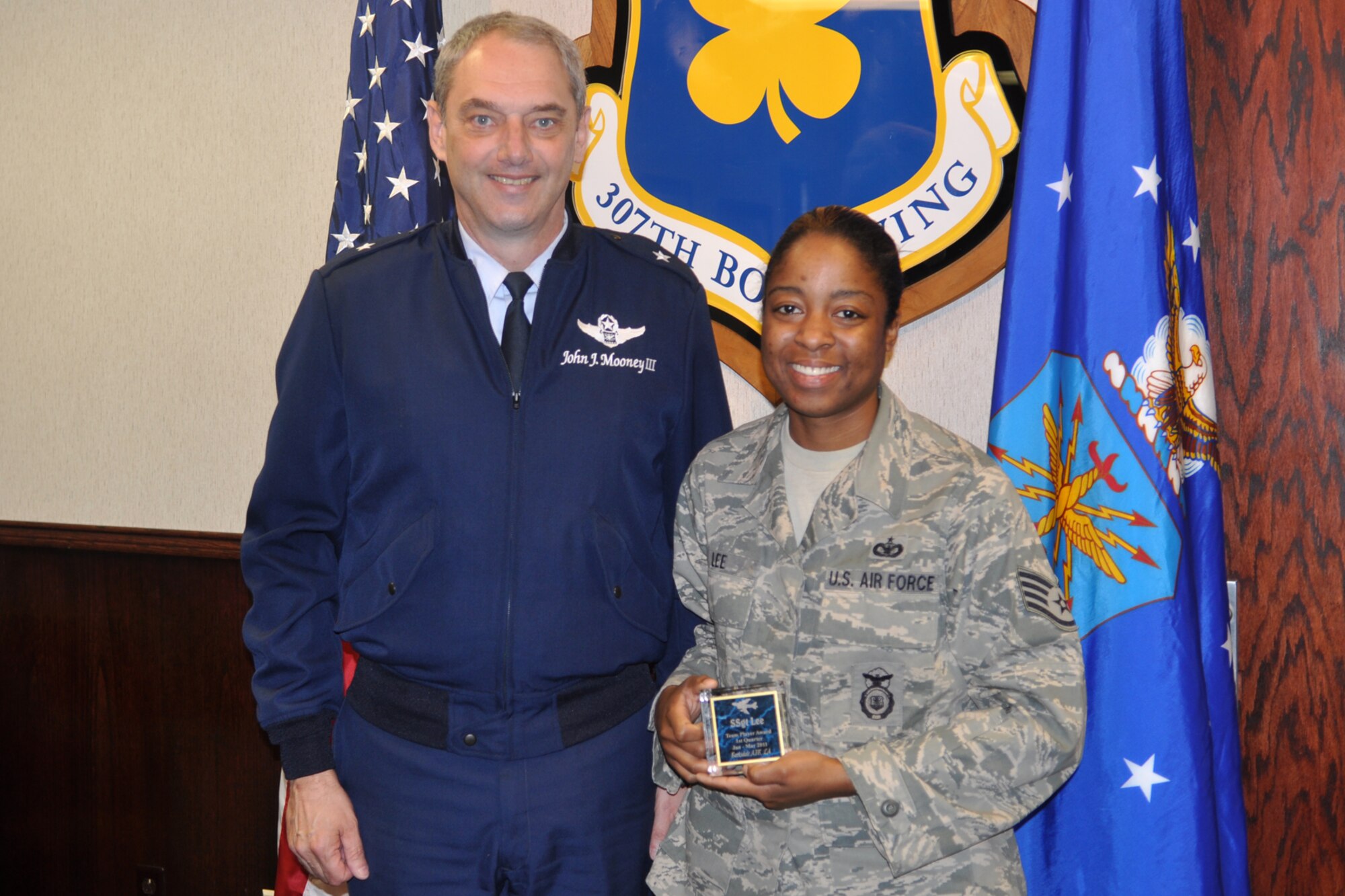 Brig. Gen. John J. Mooney III, commander, 307th Bomb Wing, and Staff Sgt. Venita Lee, line recruiter, 307th BW, pose for a photo during the Recruiters Quarterly Awards Ceremony at Barksdale Air Force Base, La., March 4, 2011. Sergeant Lee won the “Team Player Award” for the first quarter of 2011.