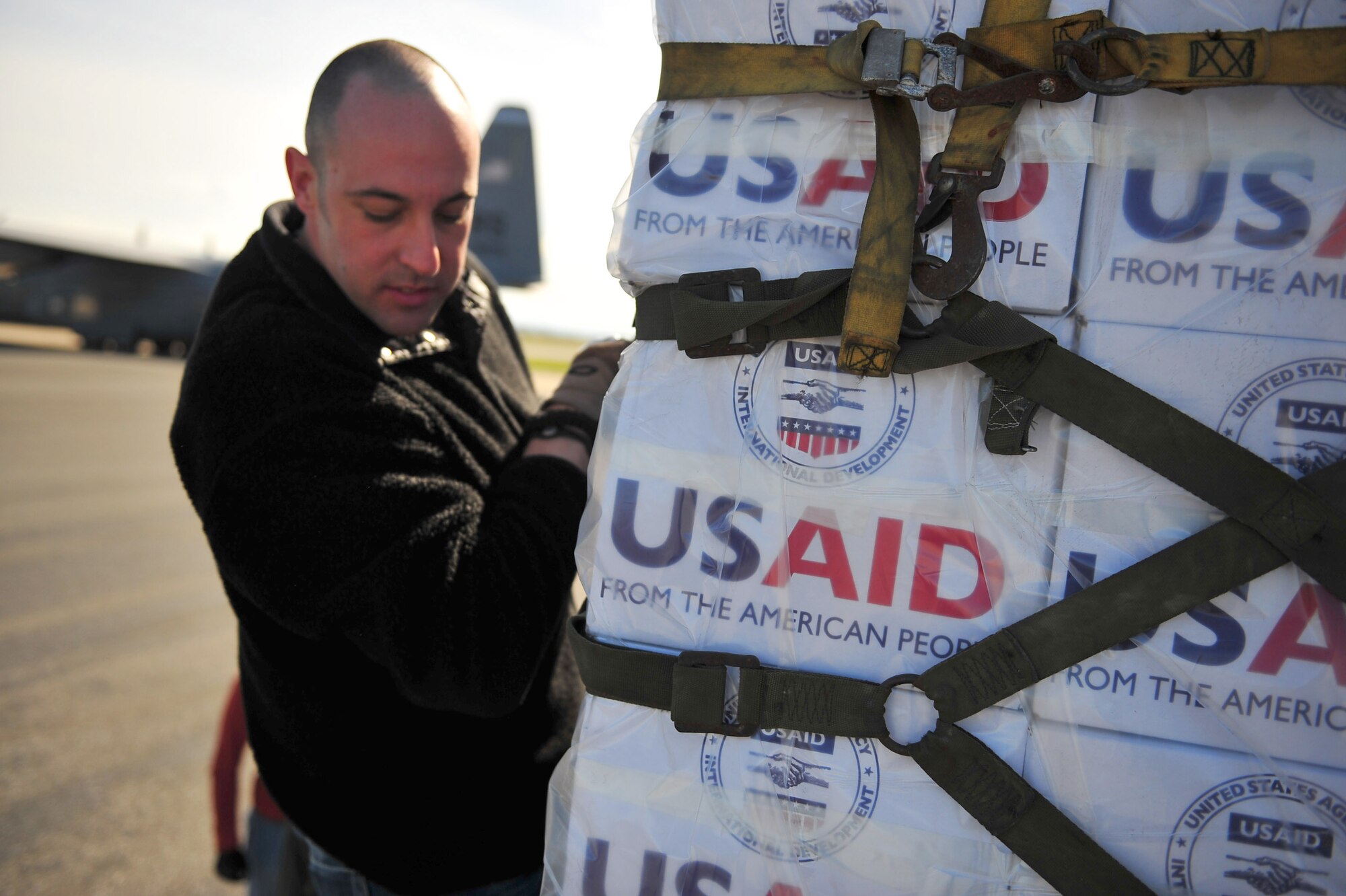 U.S. Airmen from the 435th Air Mobility Squadron, from Ramstein Air Base, Germany, load blankets, tarps and water containers onto C-130 aircraft in Pisa, Italy, March 4, 2011. The aircraft flew the supplies to Tunisia as part of the U.S. government's efforts with the international community to meet the humanitarian needs of the Lybian people and others in the country who fled across the borders during political uprisings. (U.S. Army photo by Staff Sgt. Brendan Stephens)  
