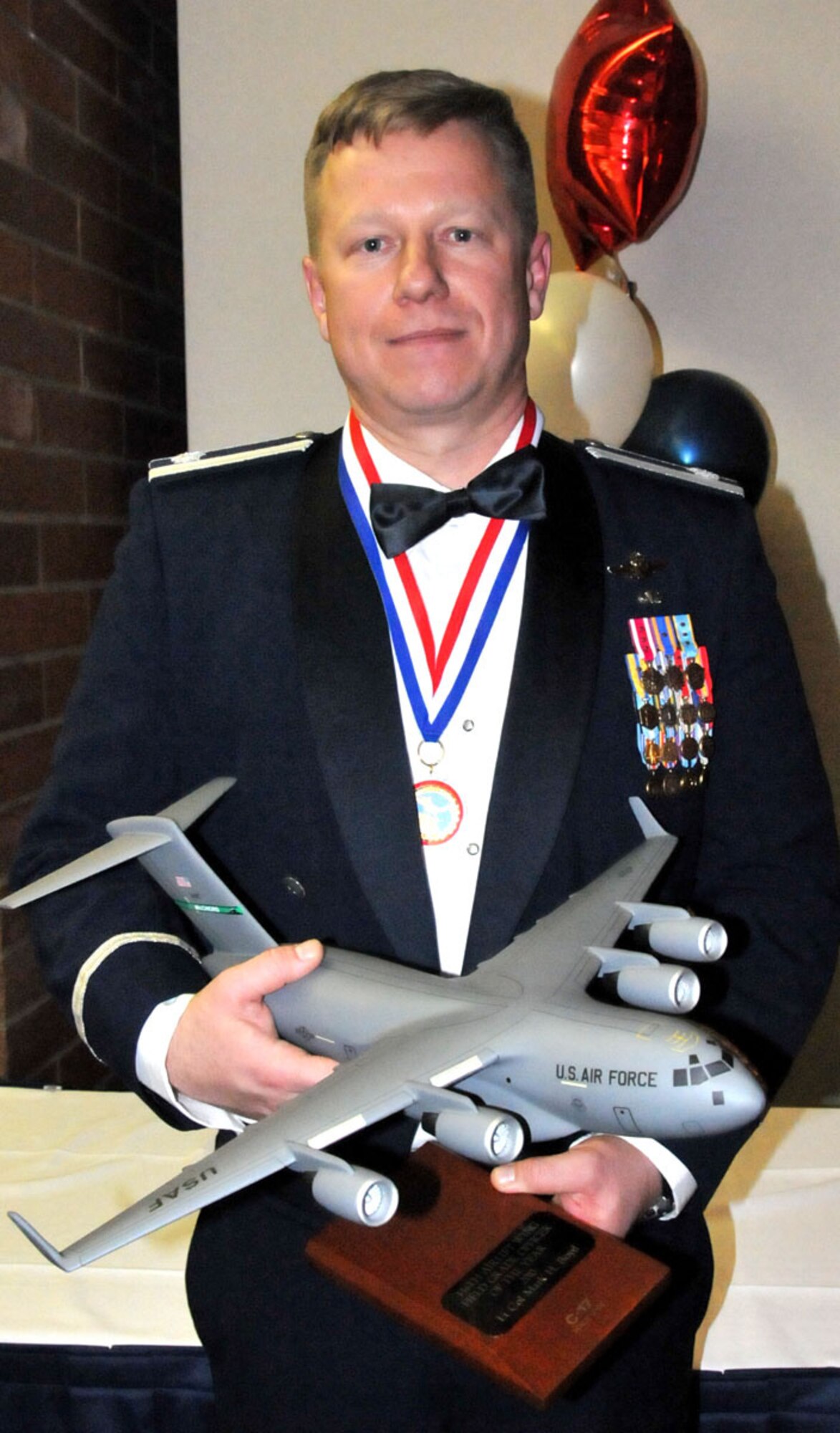 U.S. Air Force Lt. Col. Mark Boyd, 446th Operation Support Flight out of McChord Field, Wash., stands with his 446th Airlift Wing Field Grade Officer of the Year trophy from the 2011 446th Airlift Wing Annual Awards banquet, Co-located Club, March 5, 2011. (U.S. Air Force photo by 2nd Lt. Denise Hauser/Released)