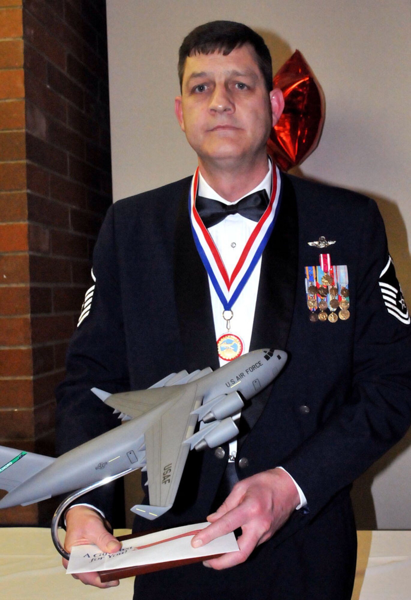 U.S. Air Force Master Sgt. Kelly Henderson, 97th Airlift Squadron loadmaster out of McChord Field, Wash., stands with his 446th Airlift Wing NCO of the Year trophy from the 2011 446th Airlift Wing Annual Awards banquet, Co-located Club, March 5, 2011. (U.S. Air Force photo by 2nd Lt. Denise Hauser/Released)