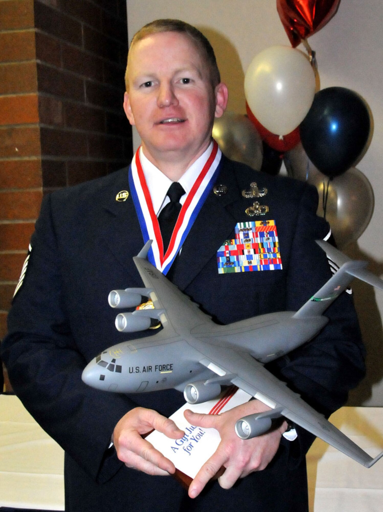 U.S. Air Force Master Sgt. Glen Tuttle, 446th Civil Engineer Squadron, Explosive Ordnance Disposal Flight out of McChord Field, Wash., stands with his 446th Airlift Wing NCO of the Year trophy from the 2011 446th Airlift Wing Annual Awards banquet, Co-located Club, March 5, 2011. (U.S. Air Force photo by 2nd Lt. Denise Hauser/Released)