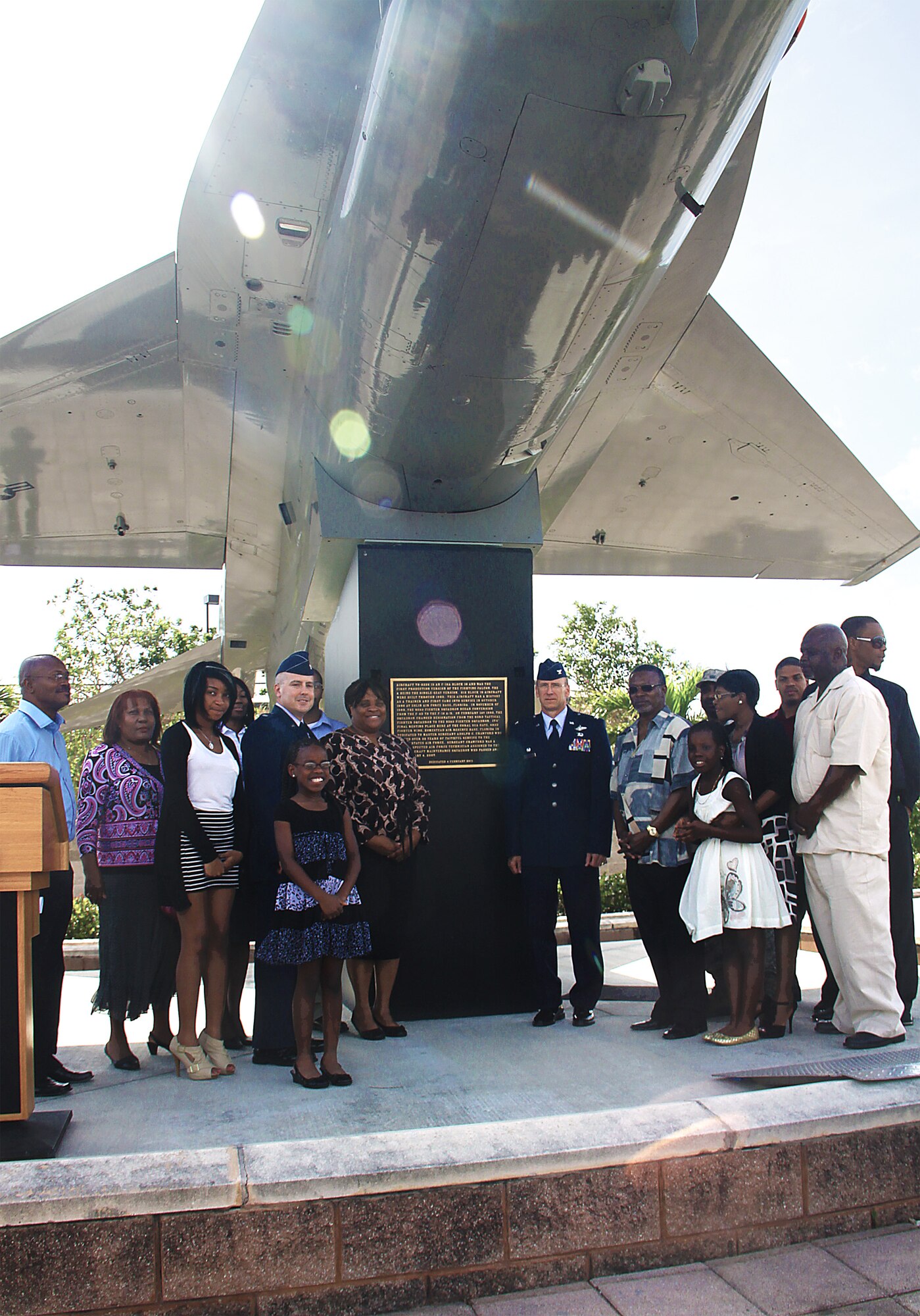 Colonel Donald Lindberg, 482d Commander, along with Mrs. Bobbie Crawford, and family and friends, unveil a plaque dedicated to Master Sgt Adolf Crawford on March 6. The plaque was attached to the F-16 A Coral Sea Boulevard monument outside the base gates. (Photo by Senior Airman Lou Burton, 482d Public Affairs)