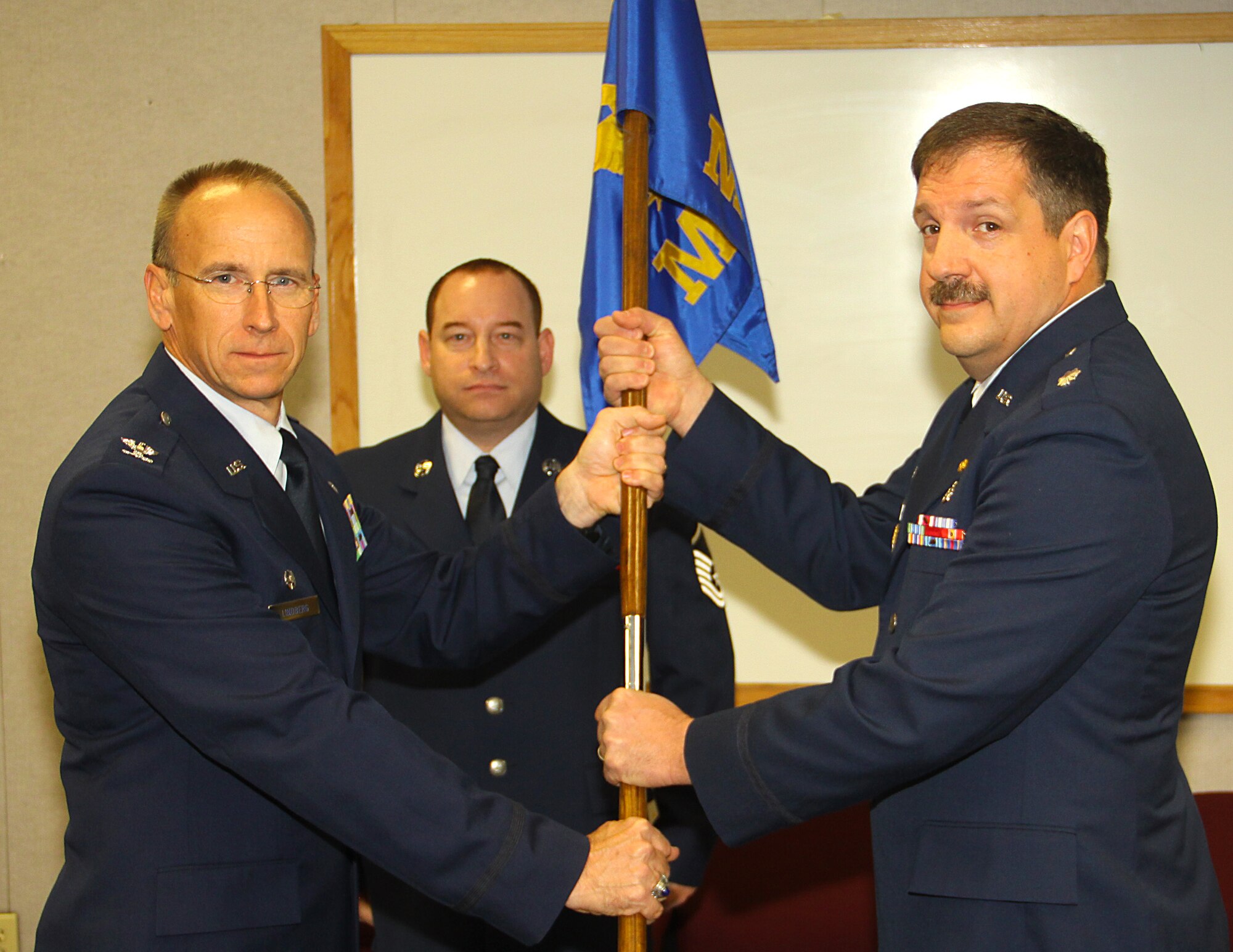 Colonel Donald Lindberg, 482d Commander, passes the guideon to Lt. Colonel Patrick Carpenter as the new commander of the 482d Medical Squadron on March 6. (US Air Force photo by Senior Airman Lou Burton, 482d Public Affairs)