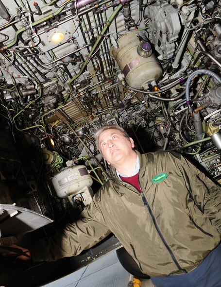 RAF MILDENHALL, England -- Steve Walkley, Trailboss Enterprises Inc (contractors, referred to basewide as "Transient Alert) regional vice president (Europe and the Middle East) does a check on the underside of a U.S. Navy C-40, to ensure everything is as it should be, and that there are no breakages, leaks or maintenance problems. Mr. Walkley performs many of the jobs his staff does, including driving the Follow Me truck, marshalling in the transient aircraft, and performing maintenance checks. (U.S. Air Force photo/Karen Abeyasekere)