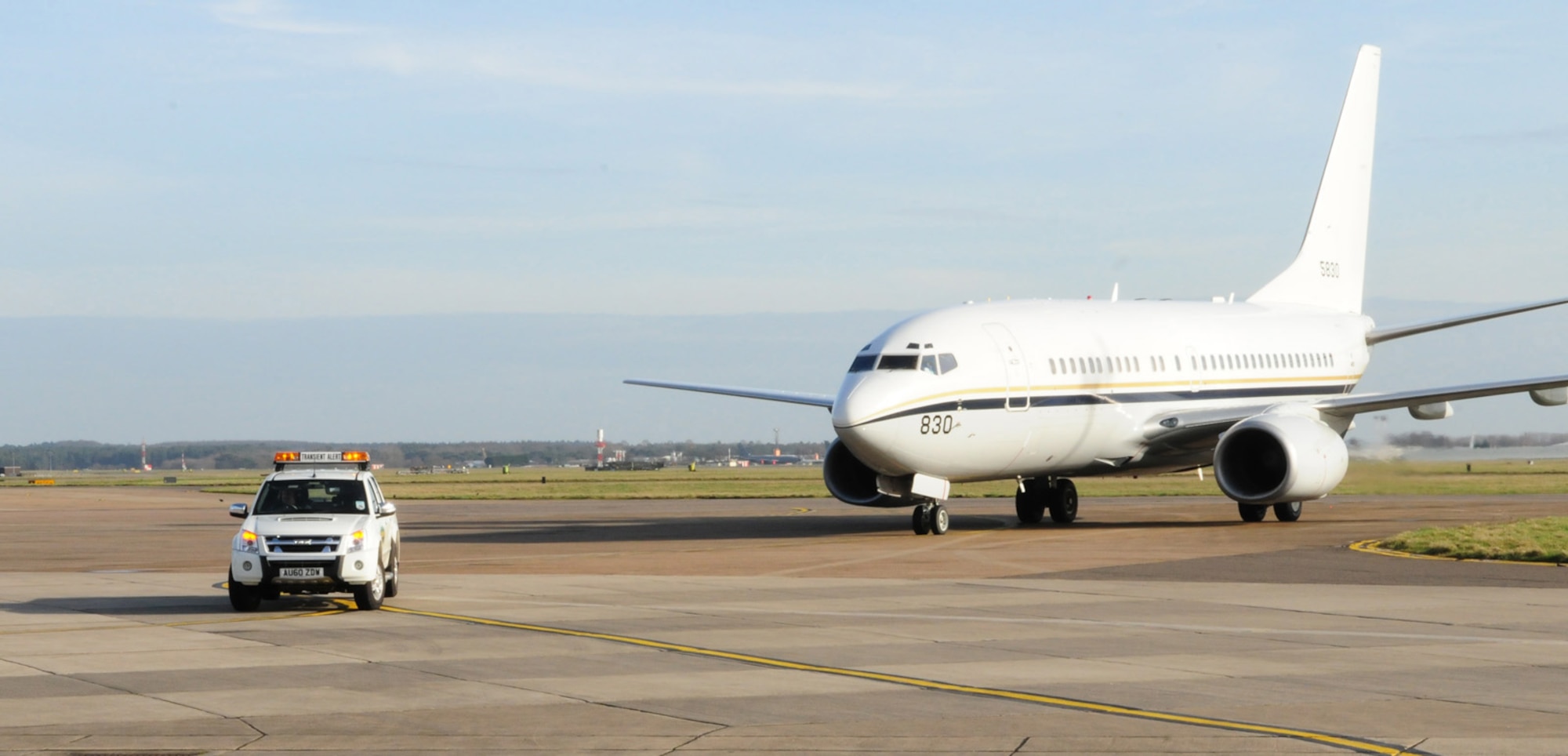 RAF MILDENHALL, England -- One of Transient Alert's drivers and "Follow Me" trucks leads a U.S. Navy C-40 aircraft into its parking spot Feb. 24, 2011. TA then ensure the aircraft is parked safely, and any necessary refueling or maintenance is taken care of before the pilots have to leave. (U.S. Air Force photo/Karen Abeyasekere)
